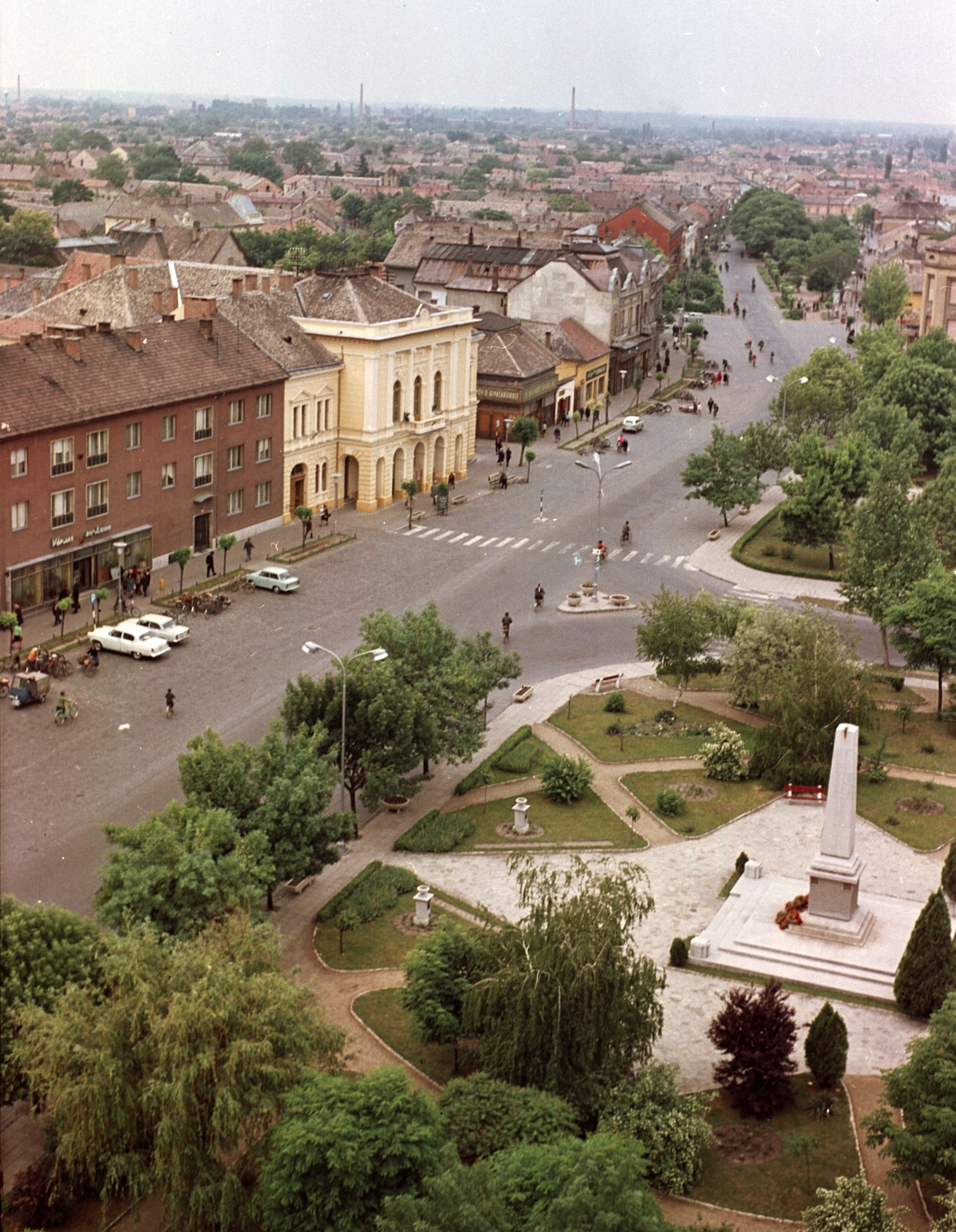 Magyarország, Nagykőrös, Szabadság tér a református templom tornyából, szemben az Arany János Művelődési Központ., 1968, Építésügyi Dokumentációs és Információs Központ, VÁTI, színes, kerékpár, kerékpár tároló, Fortepan #28997