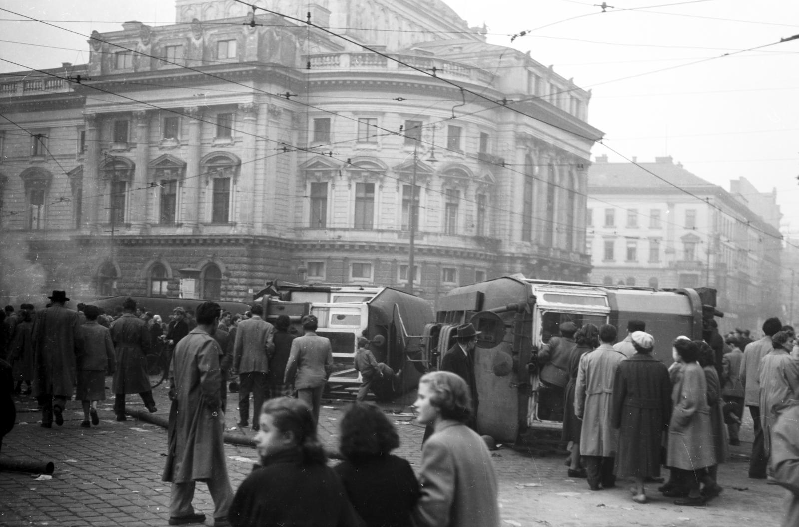 Magyarország, Budapest VIII., József körút, felborított villamosok a Népszínház utca torkolatánál. Háttérben a Nemzeti Színház a Blaha Lujza téren. Távolabb a Rákóczi út sarkán az Emke-ház látható., 1956, Fóti István örökösei, Budapest, forradalom, járműroncs, Fortepan #290061