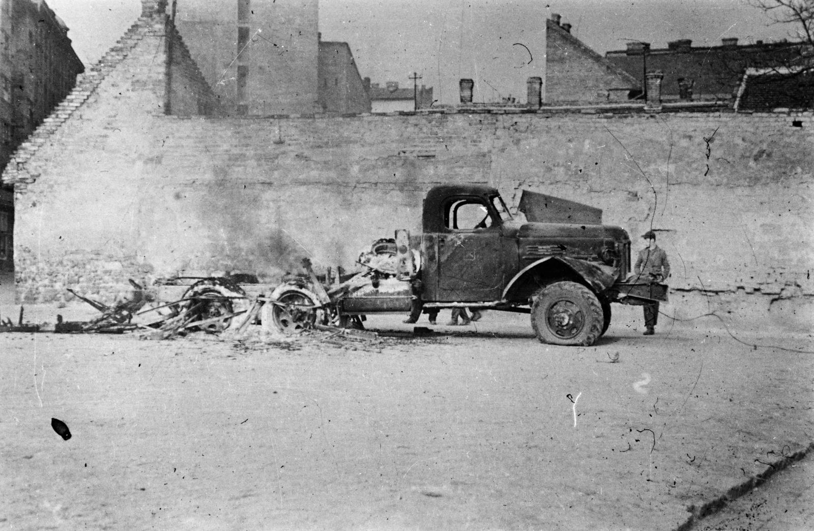 Magyarország, Budapest VIII., Bókay János utca, a kiégett teherautó a mára megszűnt szakasz üres telkén áll. Balra az egykori Beniczky utca házsora., 1956, Fóti István örökösei, forradalom, járműroncs, Zisz-157, Budapest, Fortepan #290069