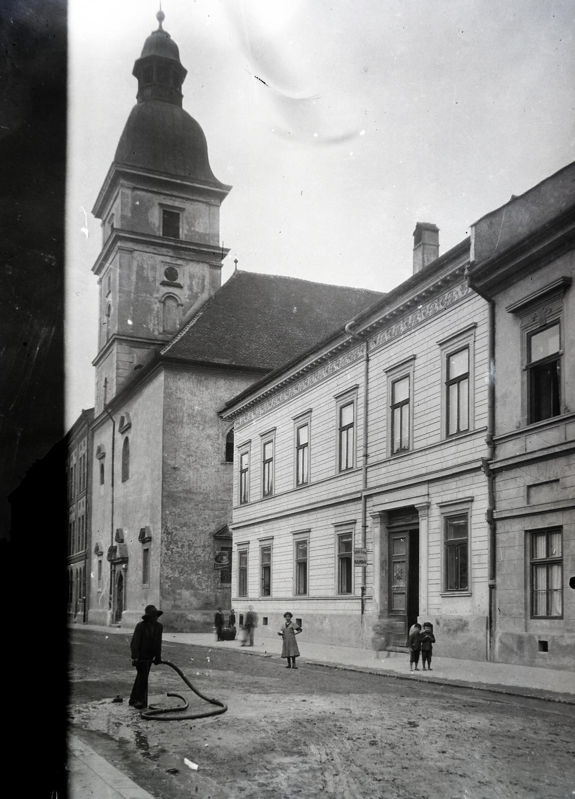 Szlovákia, Kassa, Mészáros utca (Mäsiarska ulica), az Orsolya-rendi templom., 1915, Hodosi Róbert, locsolócső, földút, templom, lakóház, Fortepan #291122