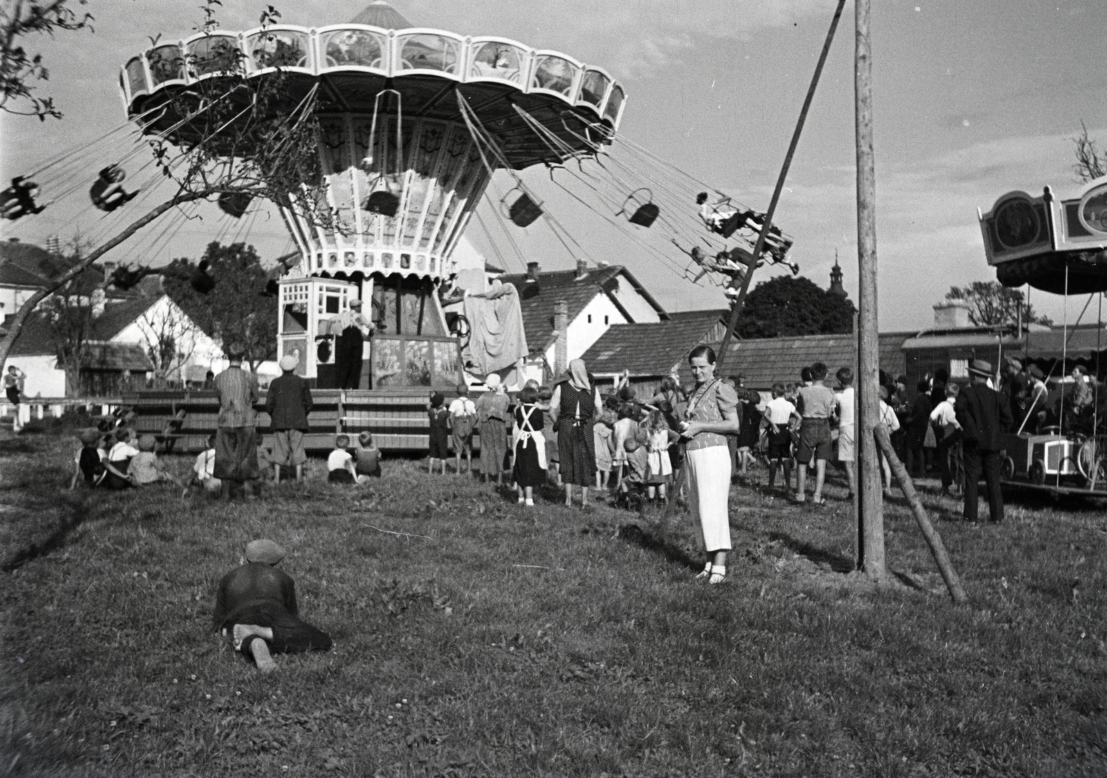 Austria, a felvétel egy búcsúban készült. Jobbra a távolban a római katolikus templom (Pfarrkirche hll. Peter und Paul) toronycsúcsa látszik., 1936, Nagy Emese, carousel, Fortepan #291858