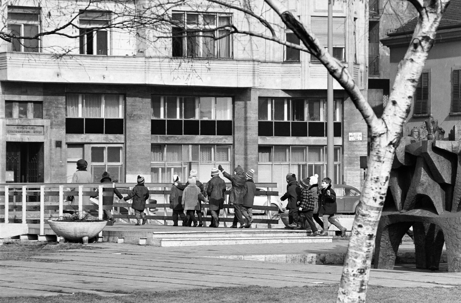 Magyarország, Budapest V., Március 15. tér, a római romterület (Contra-aquincum) bemutatóhely. Jobbra Barbárok harca a rómaiakkal szökőkút / szoborcsoport Tar István szobrászművész alkotása (1971)., 1972, Inkey Tibor, Budapest, kézenfogva, diák, Fortepan #292395