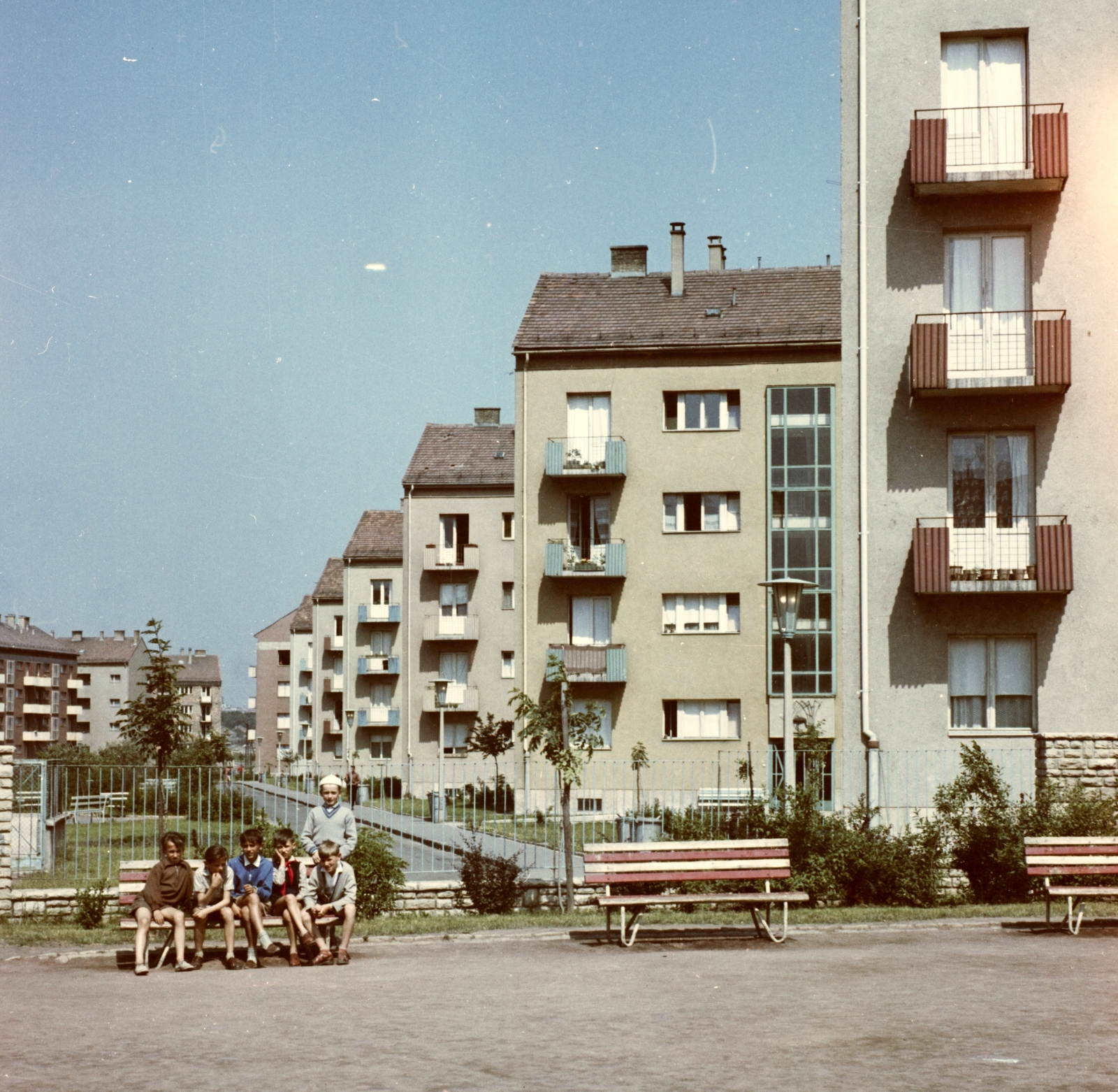 Hungary, Uránváros, Pécs, Kőrösi Csoma Sándor utca a Radnóti Miklós Szakközépiskola udvarából nézve., 1963, Építésügyi Dokumentációs és Információs Központ, VÁTI, colorful, kids, bench, Fortepan #29259