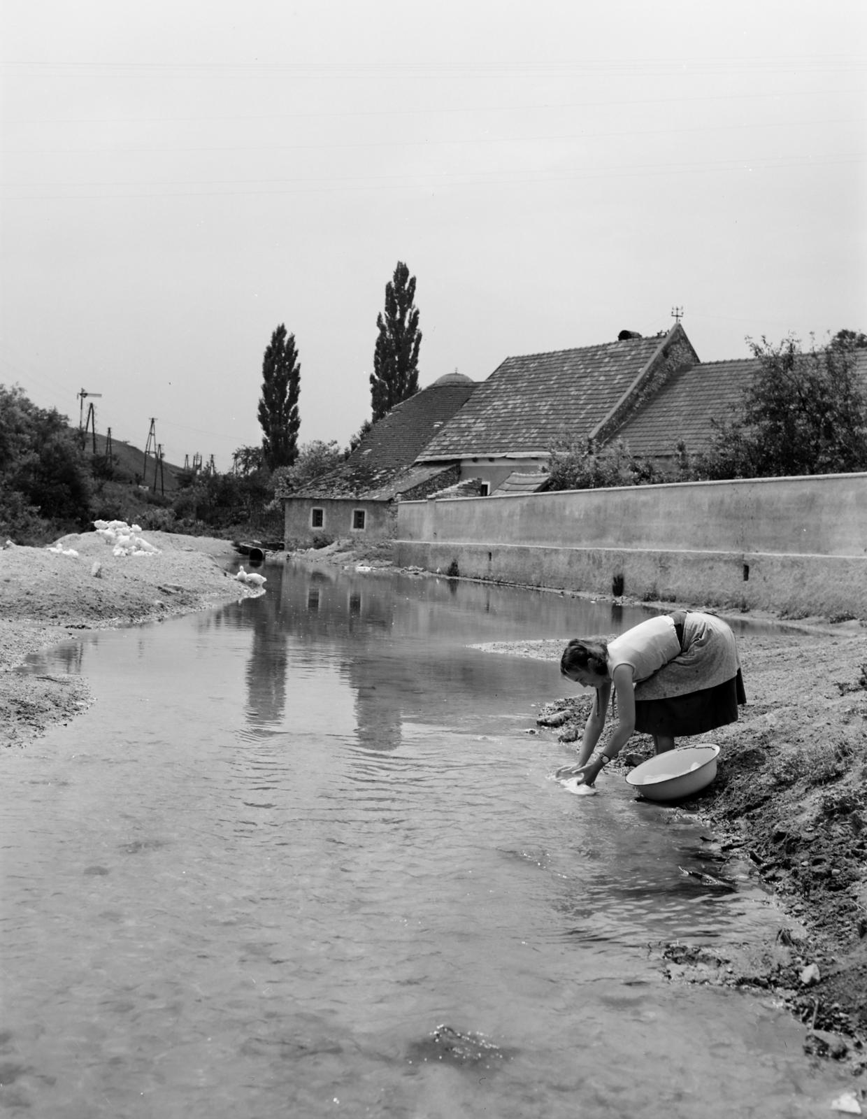 Magyarország, Öskü, patakpart, legtávolabb Klubecz Elek malma látható. A malom tetőgerincénél a Kerek templom tetejét, keresztjét látni a háttérben., 1955, Inkey Tibor, mosdótál, mosás, karóra, Fortepan #292762