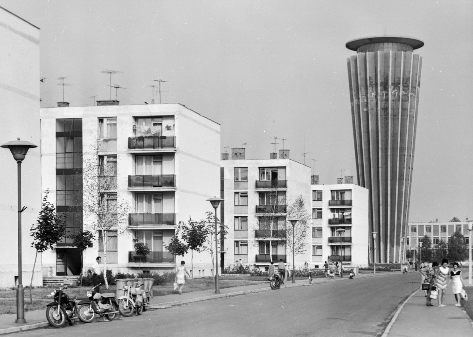 Magyarország, Tiszaújváros, (Tiszaszederkény) Tisza út a Kazinczy út felöl nézve, háttérben a víztorony., 1969, Építésügyi Dokumentációs és Információs Központ, VÁTI, motorkerékpár, lakótelep, utcakép, életkép, antenna, lámpaoszlop, kuka, Csepel Pannonia, Simson Star, Fortepan #29311