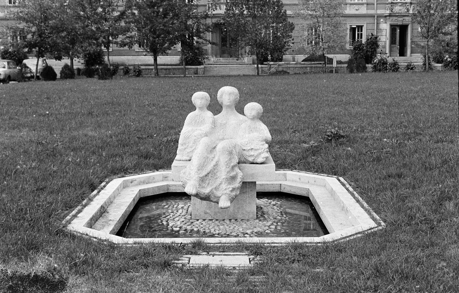 Magyarország, Eger, Barkóczy utca 5., a mai Gimnázium Park. A kútszobor Csikai Márta szobrászművész alkotása (1976). Háttérben a Ho Si Minh Tanárképző Főiskola II. számú Gyakorló Iskolája (később Eszterházy Károly Katolikus Egyetem Gyakorló Általános Iskola)., 1976, Mezei Attila, Léczfalvi, Fortepan #293289