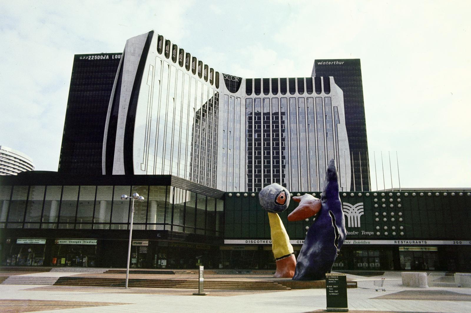 France, Puteaux, La Défense üzleti központ Párizs elővárosában. Place de la Défense, a Personnages fantastiques című szobor Juan Miró alkotása (1976). Háttérben a Les Quatre Temps bevásárlóközpont., 1983, Kristek Pál, Fortepan #294213