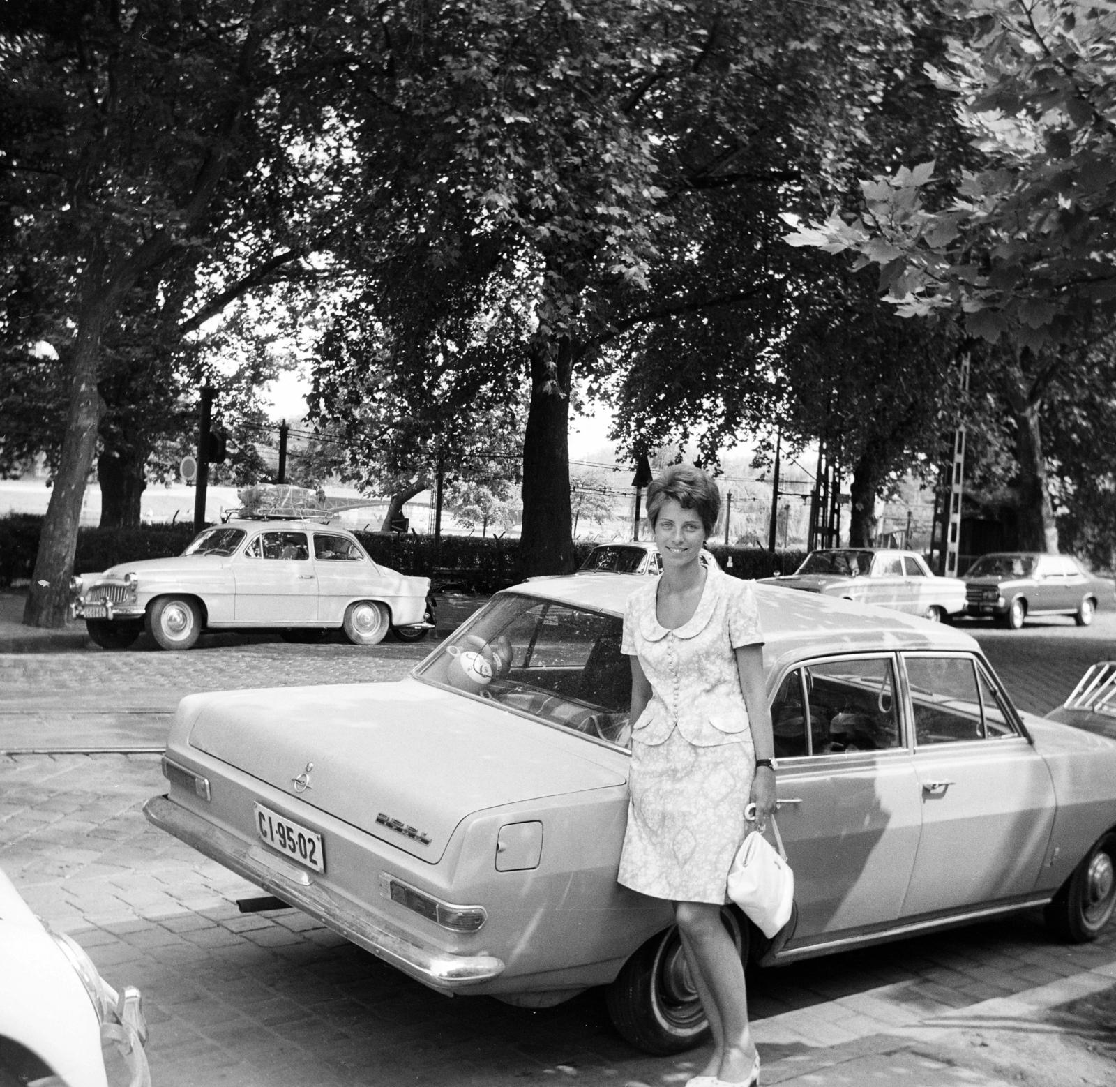 Magyarország, Budapest XIV., Állatkerti körút, háttérben a Millenniumi Földalatti Vasút mára megszűnt felszíni szakasza és a Városligeti-tó. A felvétel a Gundel étterem előtt készült. Előtérben az Opel mögött balra a Millenniumi Földalatti Vasút Dózsa György úti kocsiszín kijárati vágánya látszik., 1968, Lorkó Fanni, Budapest, lányok-járművek, Opel-márka, rendszám, Opel Rekord A, Fortepan #294232