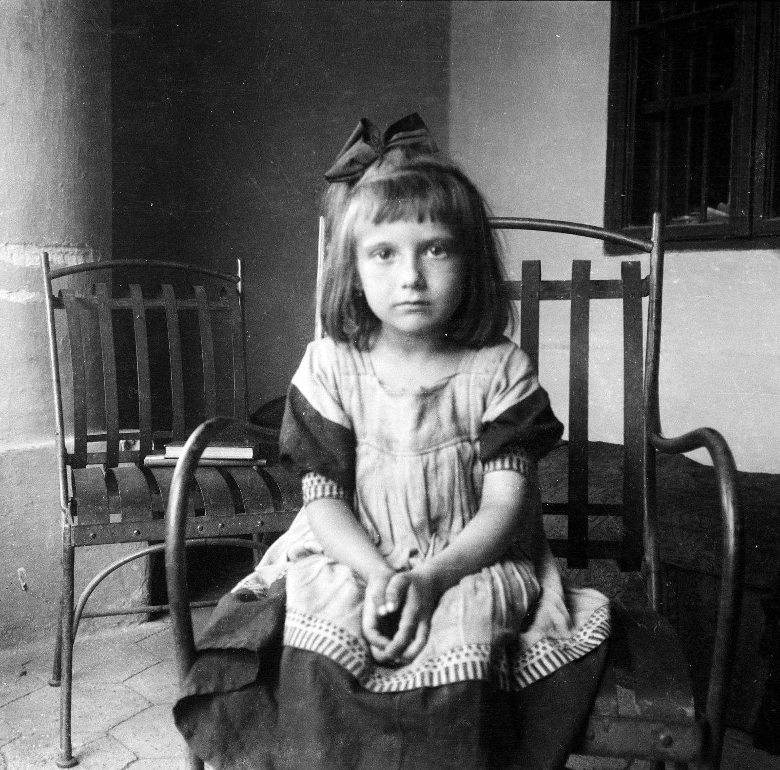 1915, Urbánné dr. Lux Judit, girl, ribbon, girl, chair, sitting with hands on knees, hair clip, arm chair, Fortepan #294655