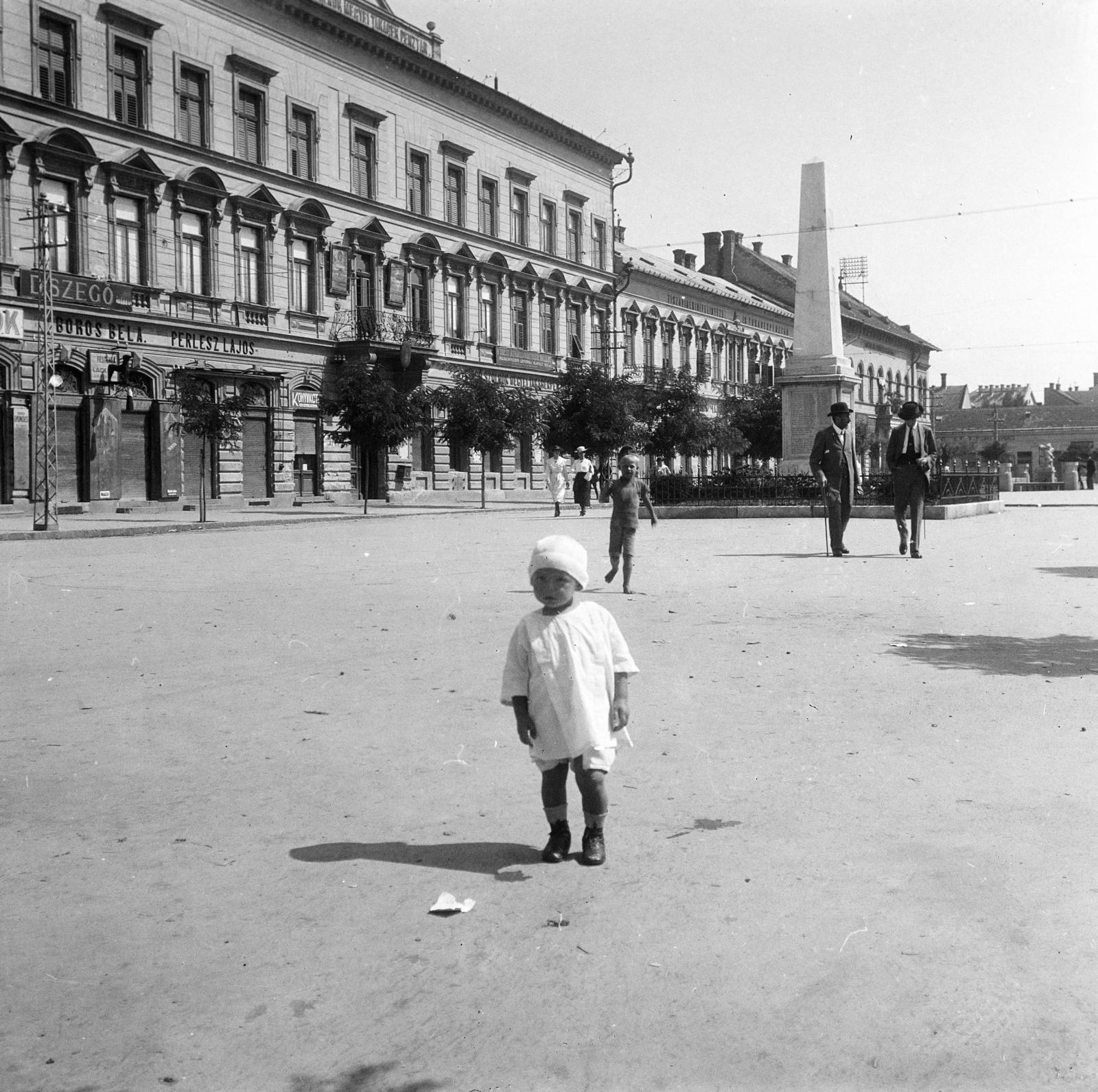 Magyarország, Szolnok, Kossuth (Piac) tér. Az 1872. június 28-án felavatott obeliszk, mely az 1866-os Königgratz melletti csatában elesett 68-as gyalogezred katonái tiszteletére állítottak fel., 1914, Urbánné dr. Lux Judit, Lux Gyula, gyerek, fehér ruha, emlékmű, képarány: négyzetes, Fortepan #294767