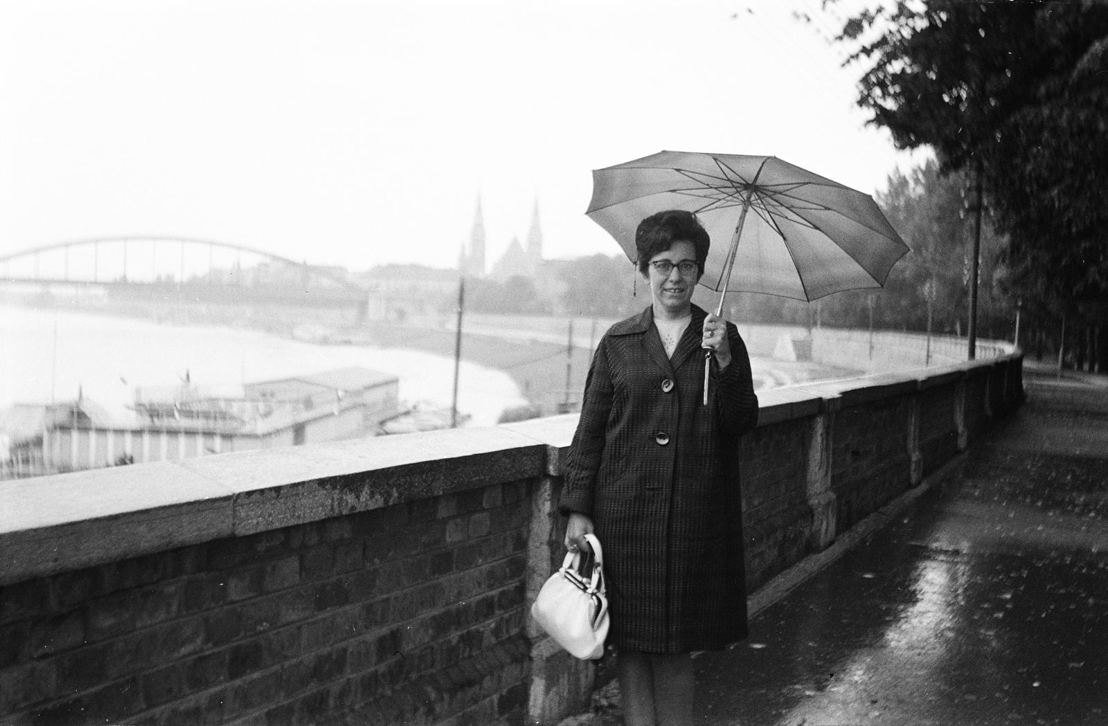 Magyarország, Szeged, Stefánia (Tanácsköztársaság útja), háttérben a Belvárosi híd és a Fogadalmi templom tornyai., 1966, Szilágyi Lajosné, esernyő, eső, támfal, Fortepan #294806