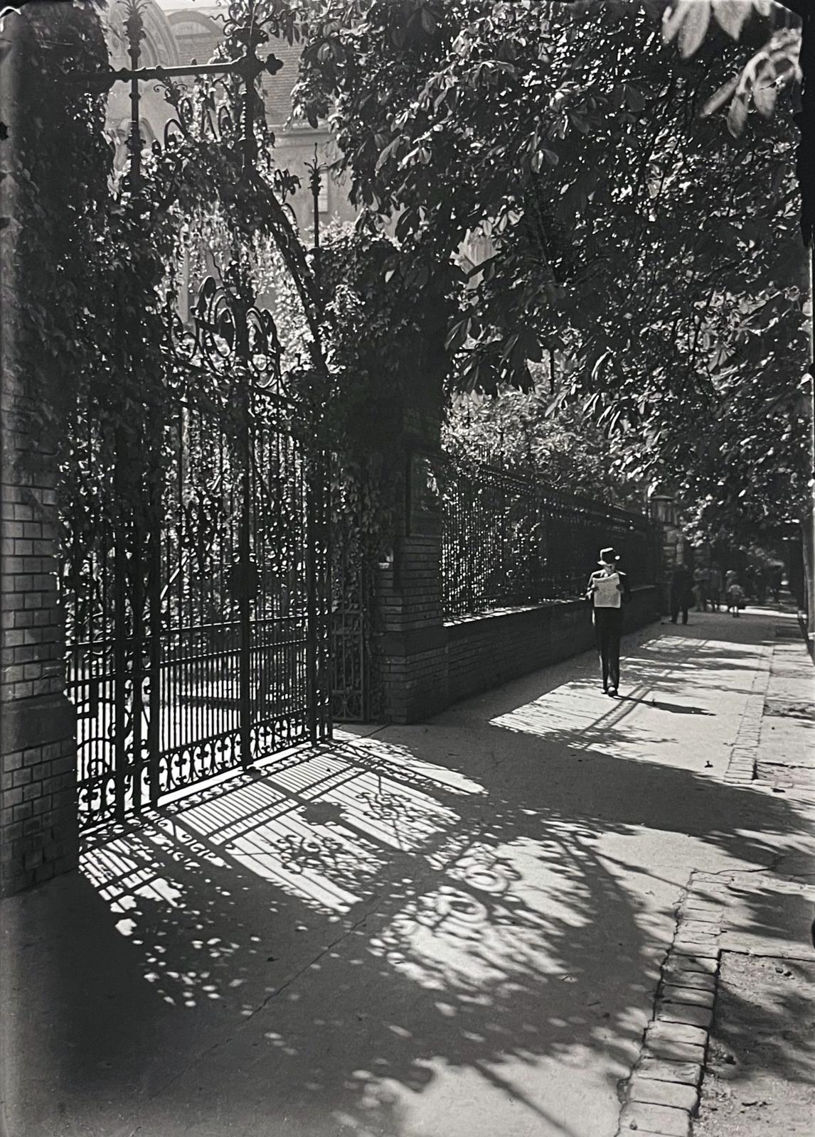 Hungary, Budapest VI., Városligeti fasor (Vilma királynő út) 49., Klösz György és fia grafikai műintézetének kapuja., 1933, Kinszki Imre, shadow, newspaper, reading, iron door, Budapest, Fortepan #295605