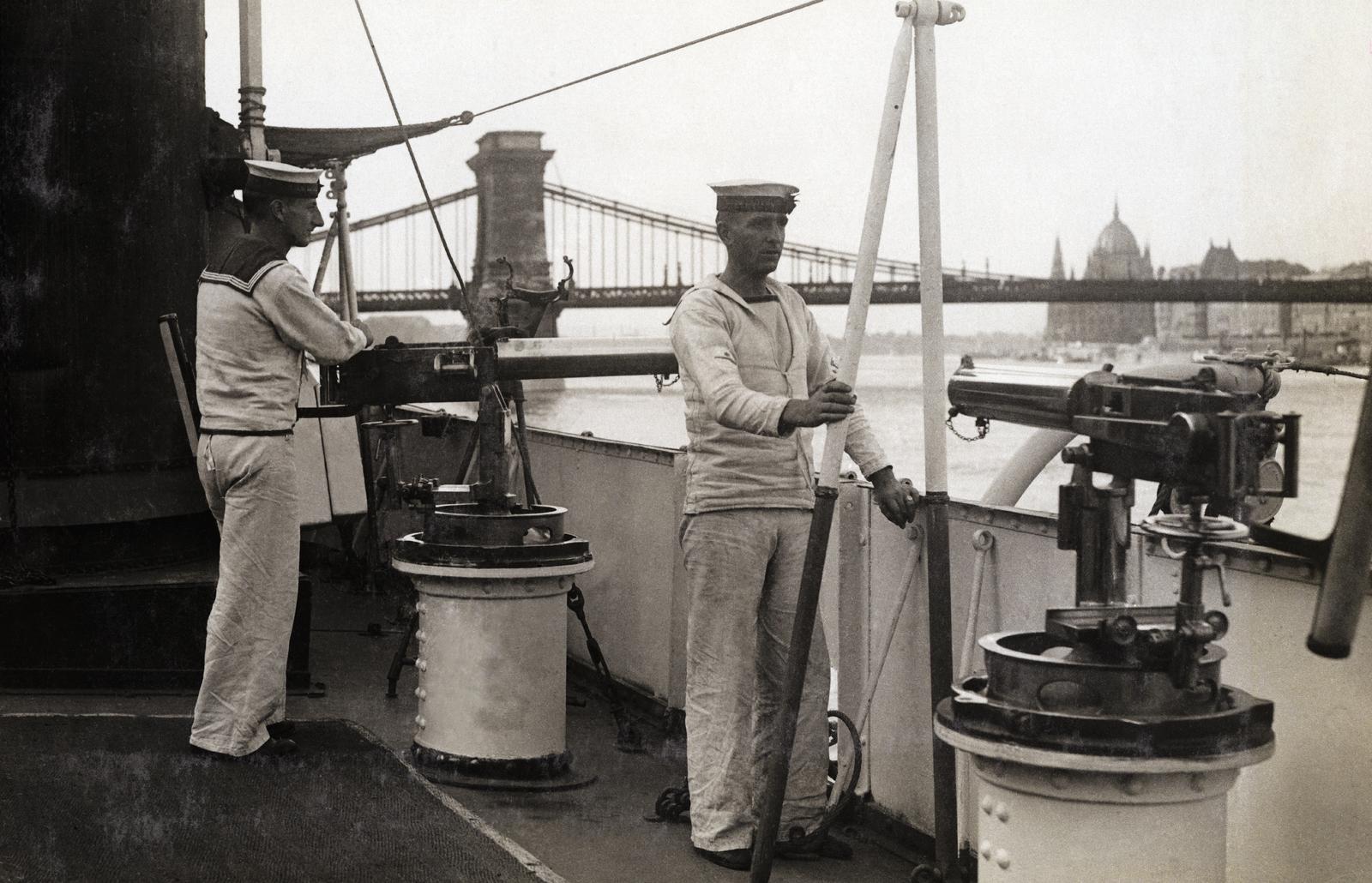 Hungary, Budapest I., a Ladybird matrózai a brit haditengerészet folyami flottillájának, a budai alsó rakpartnál kikötött, ágyúnaszádján. Háttérben a Széchenyi Lánchíd és a Parlament., 1921, Kieselbach Galéria, Best of, sailor, warship, Budapest, sailor, Danube, machine gun, Fortepan #296042
