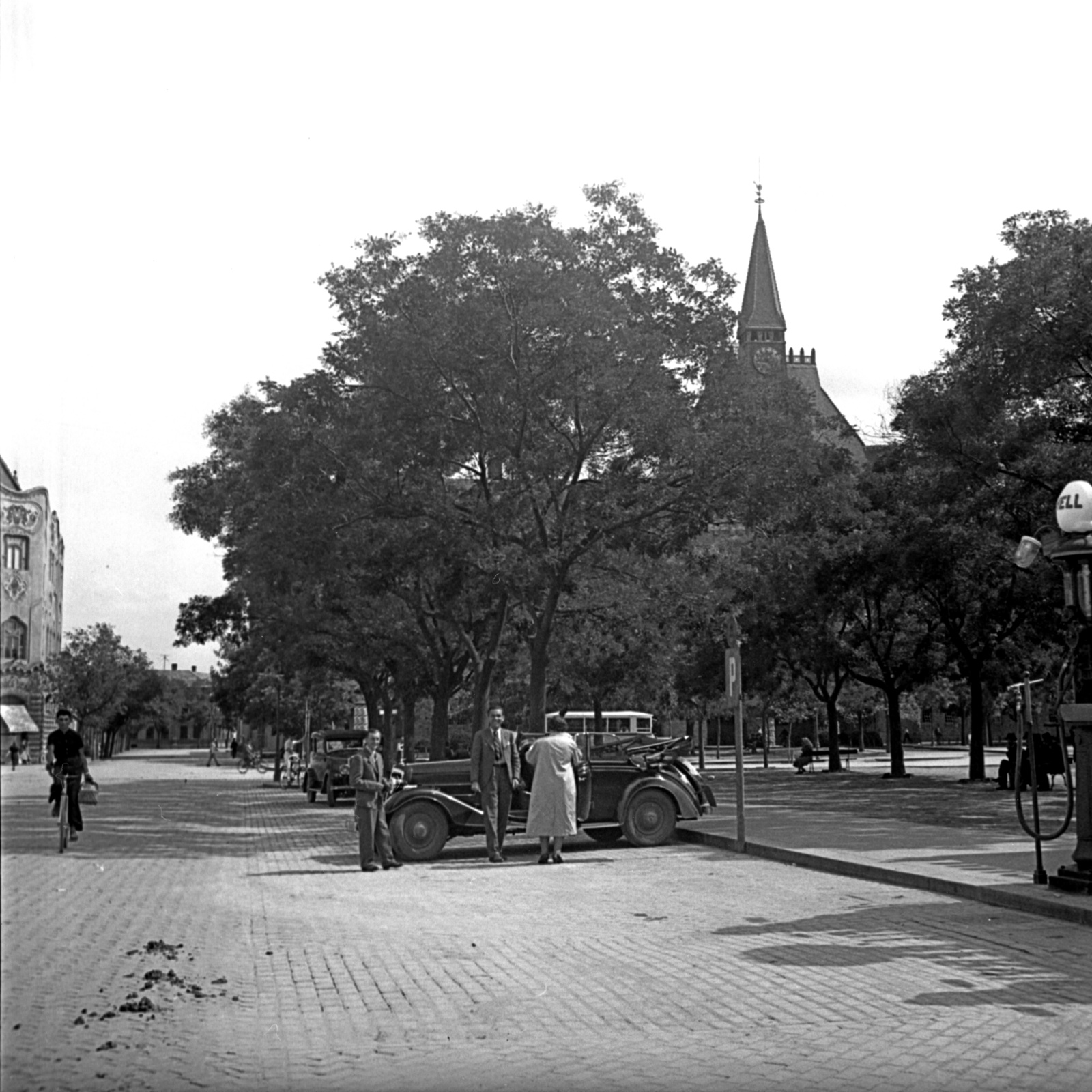 Hungary, Kecskemét, Szabadság tér, balra a Cifra Palota, a fák mögött a Kecskeméti Református Kollégium Gimnáziuma., 1938, Kölcsey Ferenc Dunakeszi Városi Könyvtár / Petanovits fényképek, bicycle, street view, Secession, gas station, automobile, Shell-brand, Géza Márkus-design, Fortepan #29693