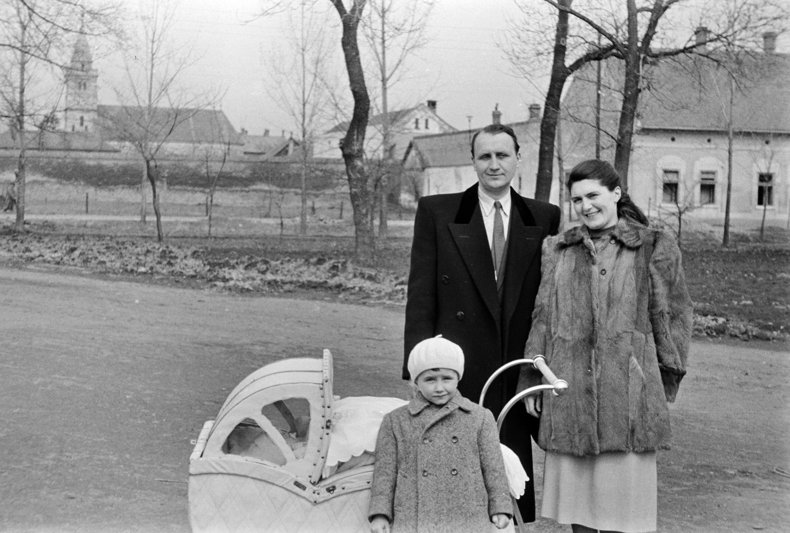 Hungary, Hódmezővásárhely, háttérben a Református Ótemplom., 1954, Németh Tamás, family, fur coat, baby carriage, beret, Fortepan #30076