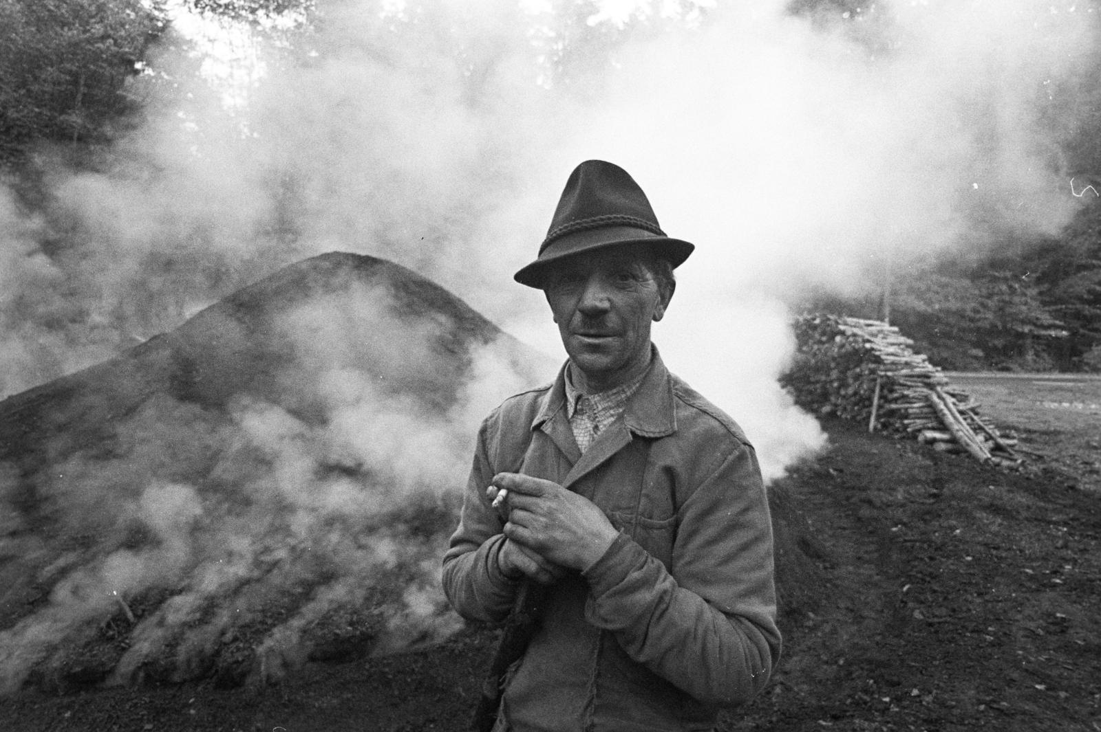 Magyarország, Répáshuta, szénégető / faszén készítő telep., 1976, Szebeni András, kihalt mesterség, farakás, portré, férfi, dohányzás, kalap, boksa, szénégetés, cigaretta, füstfelhő, Fortepan #304177