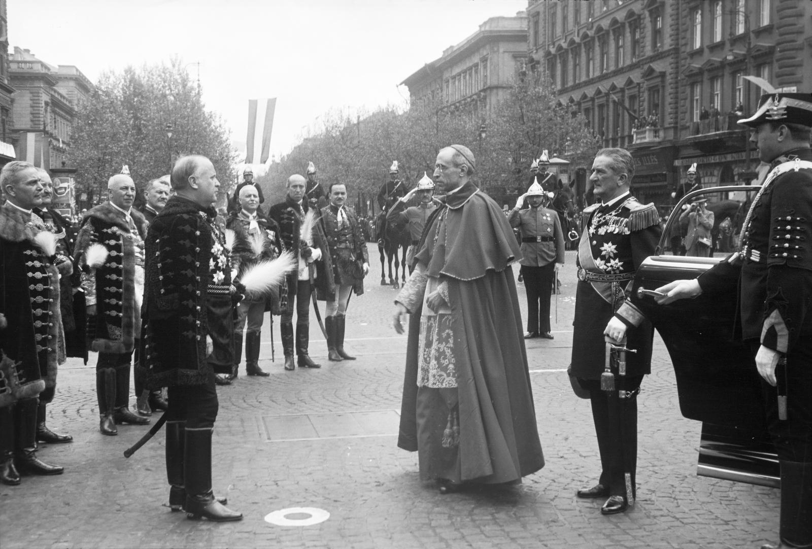 Hungary, Budapest VIII., Oktogon (Mussolini-tér), Szendy Károly polgármester köszönti az Eucharisztikus Világkongresszusra érkező, Eugénio Pacelli bíborost (későbbi XII. Pius pápa), XI. Pius pápa képviselőjét, mellette Horthy Miklós. Háttérben az Andrássy út Hősök tere felé vezető szakaszának házsora., 1938, Inkey Tibor, Budapest, Fortepan #304564