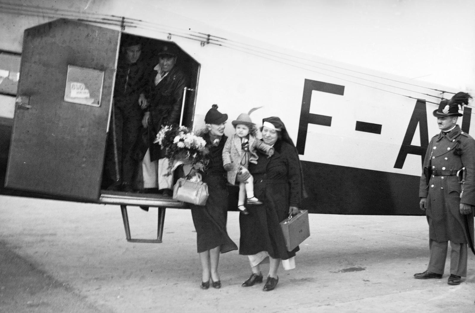 Magyarország, Mátyásföldi repülőtér, Budapest XVI., Alpár Gitta színésznő, kislányával és kisérőjükkel. A művésznő két hosszabb külföldi vendégszereplés között, 1936. március 27-én érkezett haza, pihenni., 1936, Inkey Tibor, Fokker-márka, virágcsokor, repülőgép, Air France légitársaság, apáca, csendőr, Budapest, Fortepan #304660