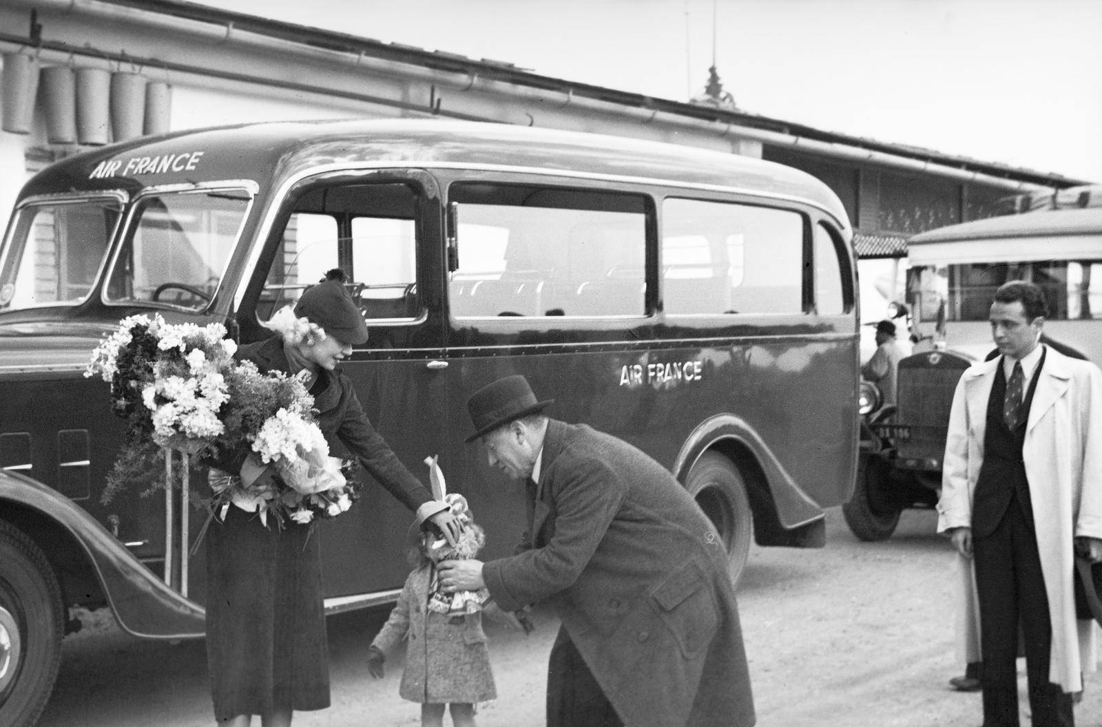 Magyarország, Mátyásföldi repülőtér, Budapest XVI., Alpár Gitta színésznő, kislányának a nagypapája matyó népviseletbe öltöztetett babát ad át unokájának. A művésznő két hosszabb külföldi vendégszereplés között, 1936. március 27-én érkezett haza, pihenni., 1936, Inkey Tibor, gyerek, Air France légitársaság, Budapest, Fortepan #304665