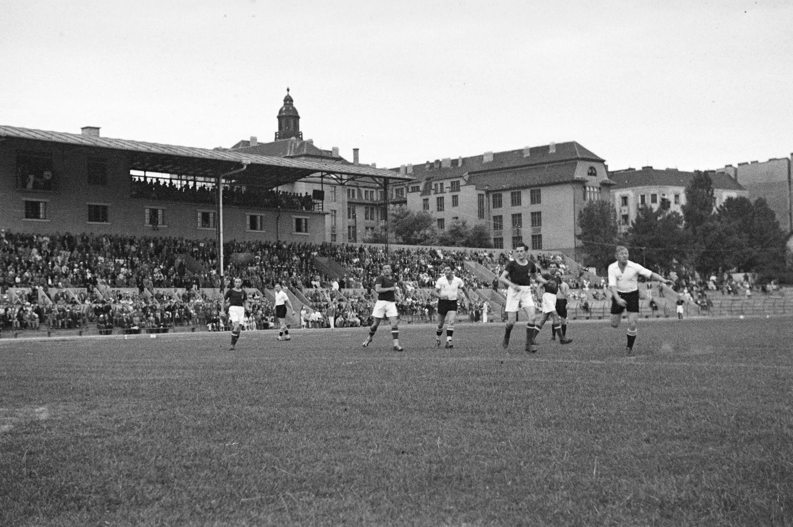 Magyarország, Budapest XI., Kőrösy József (Mező) utca, BEAC-pálya. Háttérben a tribün mögött a Váli utcai iskola (később József Attila Gimnázium) épülete. A felvétel a Magyarország - Németország válogatott nagypályás kézilabda mérközésen 1936. július 16-án készült., 1937, Inkey Tibor, labdarúgás, közönség, Budapest, Fortepan #304860