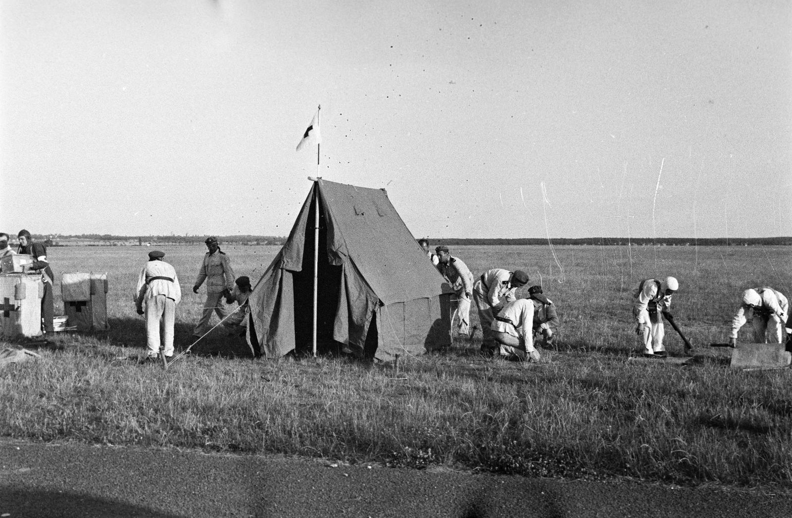 Hungary, Mátyásföld Airport, Budapest XVI., a Magyar Vörös Kereszt és a Magyar Aero Szövetség rendezésében megtartott első nemzetközi légi mentőügyi versenyek és bemutatók, 1937. június 11-14-én. A verseny résztvevői, az ejtőernyővel ledobott felszerelésekből, tábori segélyhelyet alakítanak ki., 1937, Inkey Tibor, tent, Budapest, Fortepan #304954