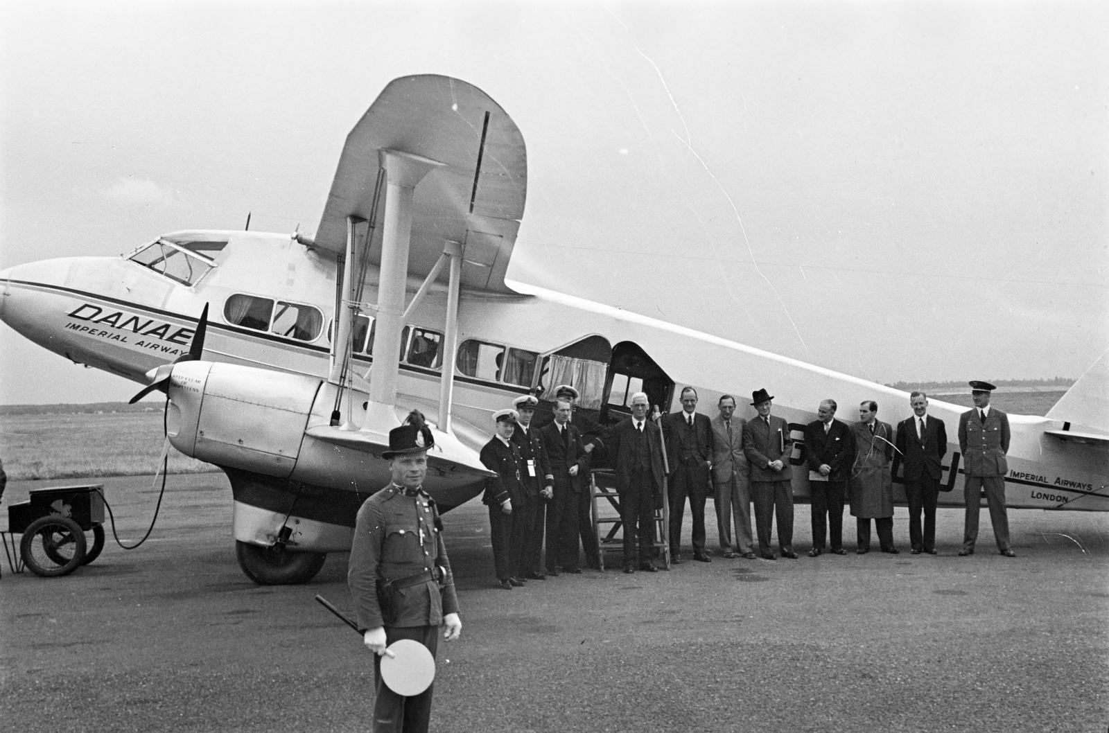 Hungary, Mátyásföld Airport, Budapest XVI., amerikai és angol újságírók küldöttsége New Yorkból a Cunard-White Line hajójával, az angol kereskedelmi hajózás új büszkeségével a Queen Maryvel indultak Európába. Cherbourgból az Imperial Airsways légitársaság De Havilland Dragon Express típusú Danae repülőgépével érkeztek Budapestre. Az utat rekordidő, 5 nap alatt tették meg., 1936, Inkey Tibor, uniform, waiting, airport, airplane, De Havilland-brand, untitled, Imperial Airways, Budapest, Fortepan #304976