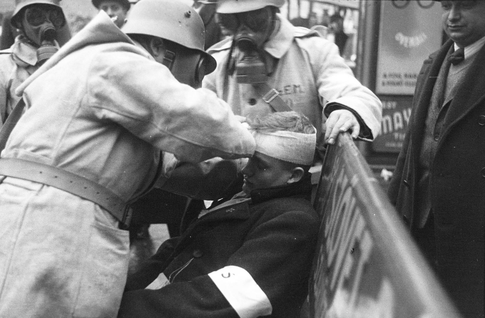 Hungary, Budapest V., Deák Ferenc tér. A felvétel a védelmi alakulatok légoltalmi gyakorlatán készült. A vöröskeresztes mentőcsapat tagjai sebesültet kötöznek., 1937, Inkey Tibor, air defense, gas mask, Budapest, Fortepan #305176