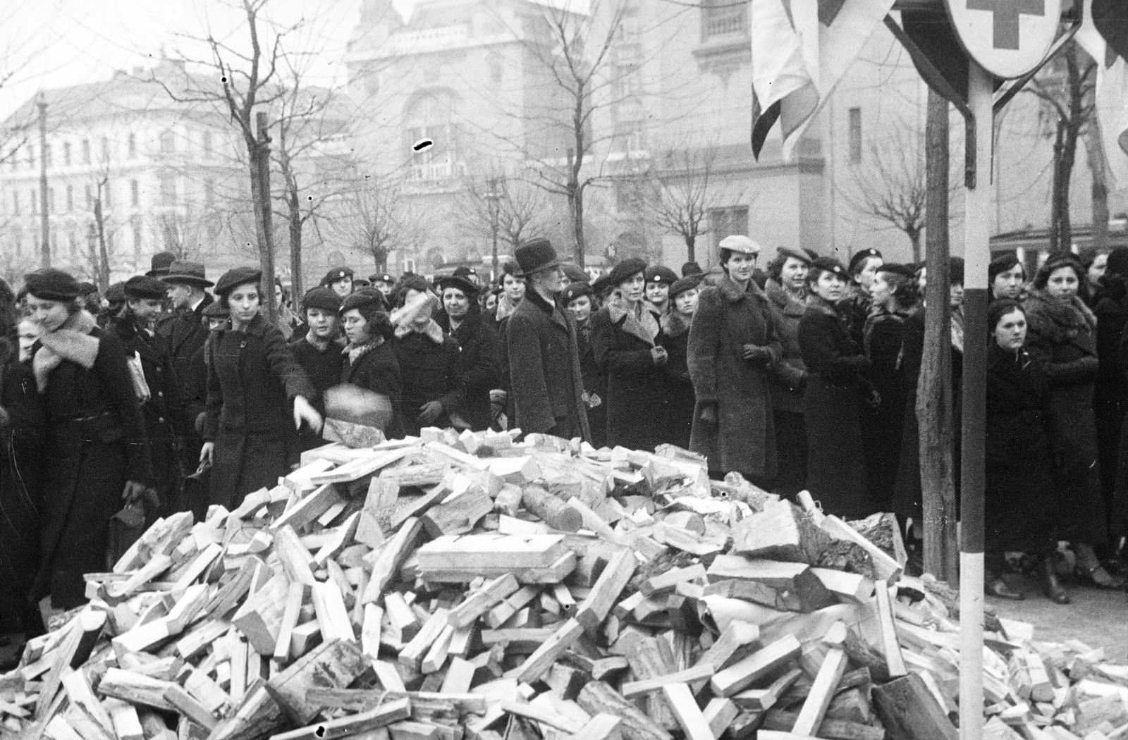 Hungary, Budapest VIII., Horváth Mihály (Mária Terézia) tér, a Vöröskereszt szervezésében, a "csak egy darab fát a szegényeknek" ínségakció, diákok tűzifát gyűjtenek a rászorulóknak. Háttérben a Német utca torkolatánál a József Telefonközpont épülete, jobbra a Szent József-templom., 1937, Inkey Tibor, Budapest, Fortepan #305184