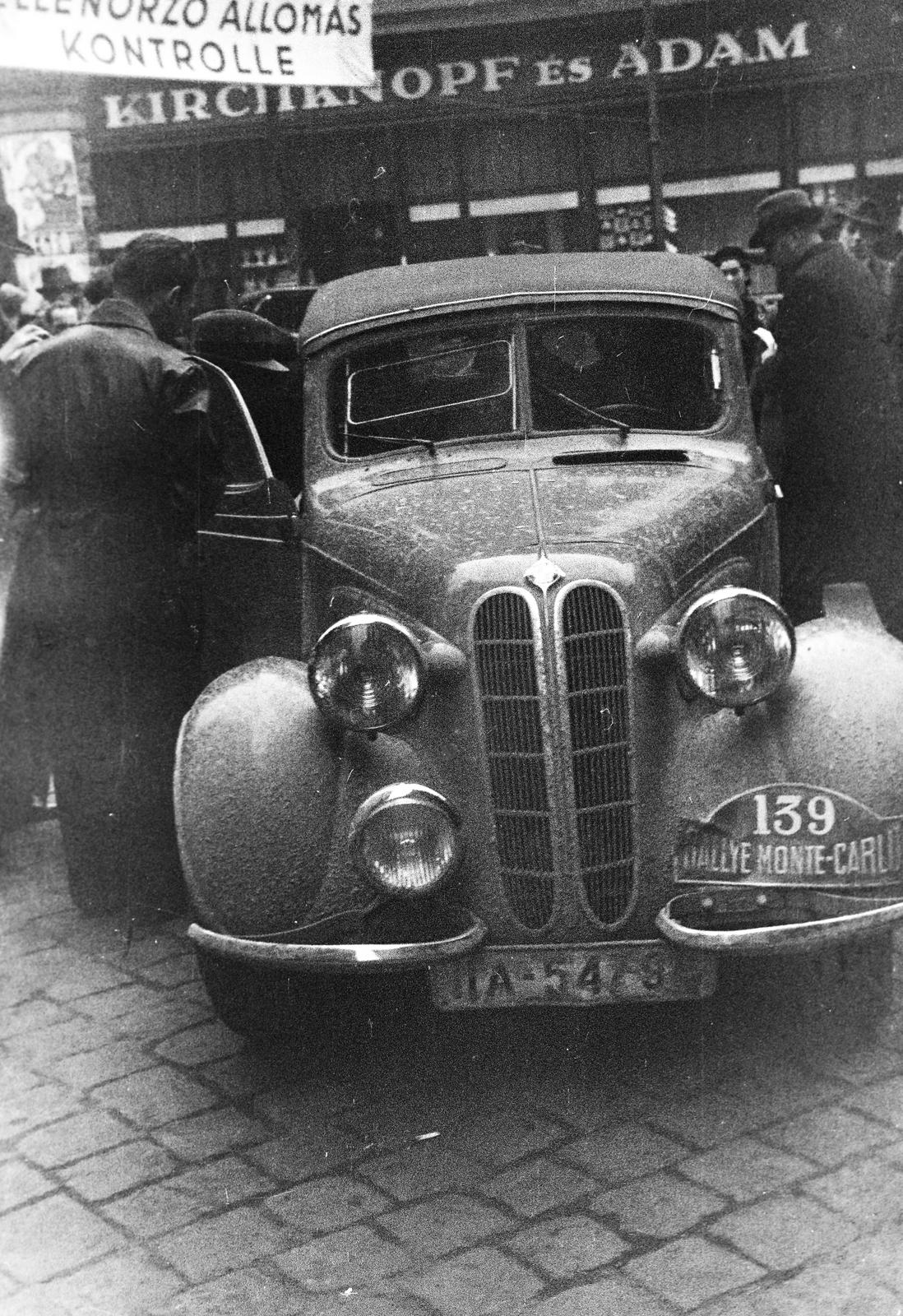 Hungary, Budapest V., Ferenciek tere, az ekkor csillagtúraként megrendezett Monte-Carlo Rallye Athénből induló 139-es rajtszámú, az angol Aldington Harold John versenyző, Frazer Nash-BMW típusú gépjárműve. A Királyi Magyar Automobil Club székhelyénél lévő ellenőrző pont, a KMAC kirendelt ellenőrei a túrakönyveket kezelik., 1938, Inkey Tibor, automobile, number plate, Budapest, Fortepan #306012
