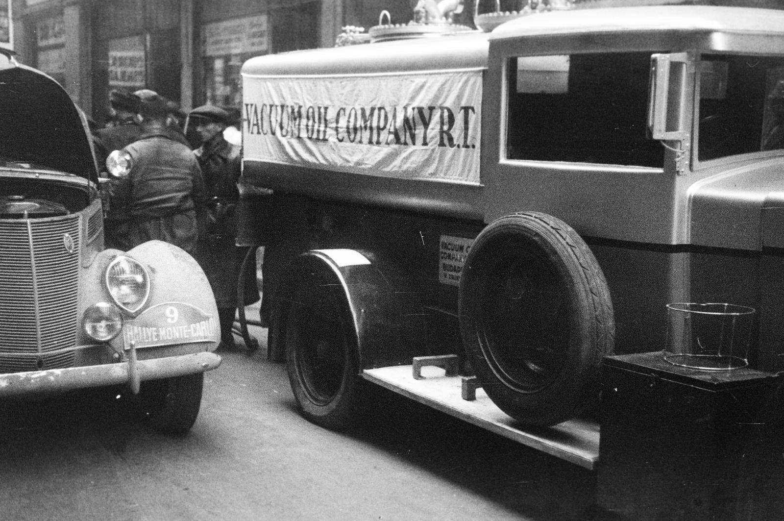 Hungary, Budapest V., Irányi utca, a 18-as számú ház előtt a Vacuum Oil Company Rt. tartályautója. Az ekkor csillagtúraként megrendezett Monte-Carlo Rallye Athénből induló 9-es rajtszámú, későbbi győztes holland Bakker-Schut Gerard - Ton Karel versenyzőpáros, Ford V8 típusú gépjárműve., 1938, Inkey Tibor, spare wheel, English sign, Mobiloil-brand, Budapest, Fortepan #306019