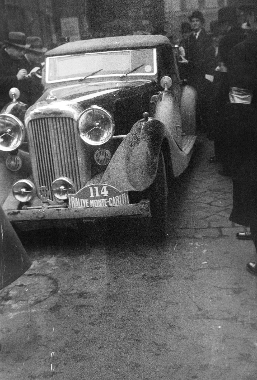 Magyarország, Budapest V., Curia utca, az ekkor csillagtúraként megrendezett Monte-Carlo Rallye Athénból induló mezőnye. Előtérben a 114-es rajtszámú versenyző, az angol A. P. Good, Lagonda típusú gépjárműve. A Királyi Magyar Automobil Club székhelyénél lévő ellenőrző pont, a KMAC kirendelt ellenőrei a túrakönyveket kezelik., 1938, Inkey Tibor, automobil, rajtszám, Budapest, Fortepan #306024