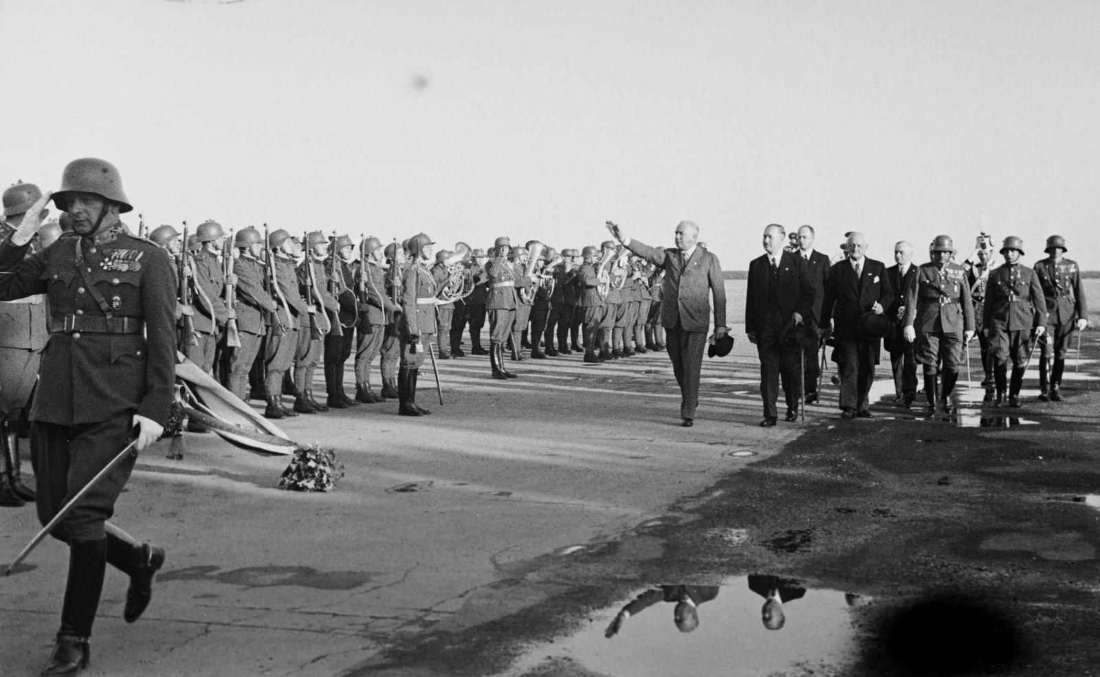 Magyarország, Mátyásföldi repülőtér, Budapest XVI., világos öltönyben a budapesti látogatásra érkező báró Konstantin von Neurath német birodalmi külügyminiszter, tőle jobbra dr. Darányi Kálmán miniszterelnök és Kánya Kálmán külügyminiszter elvonul a honvéd díszszázad és a honvédzenekar előtt., 1937, Inkey Tibor, gesztus, Budapest, Fortepan #306047