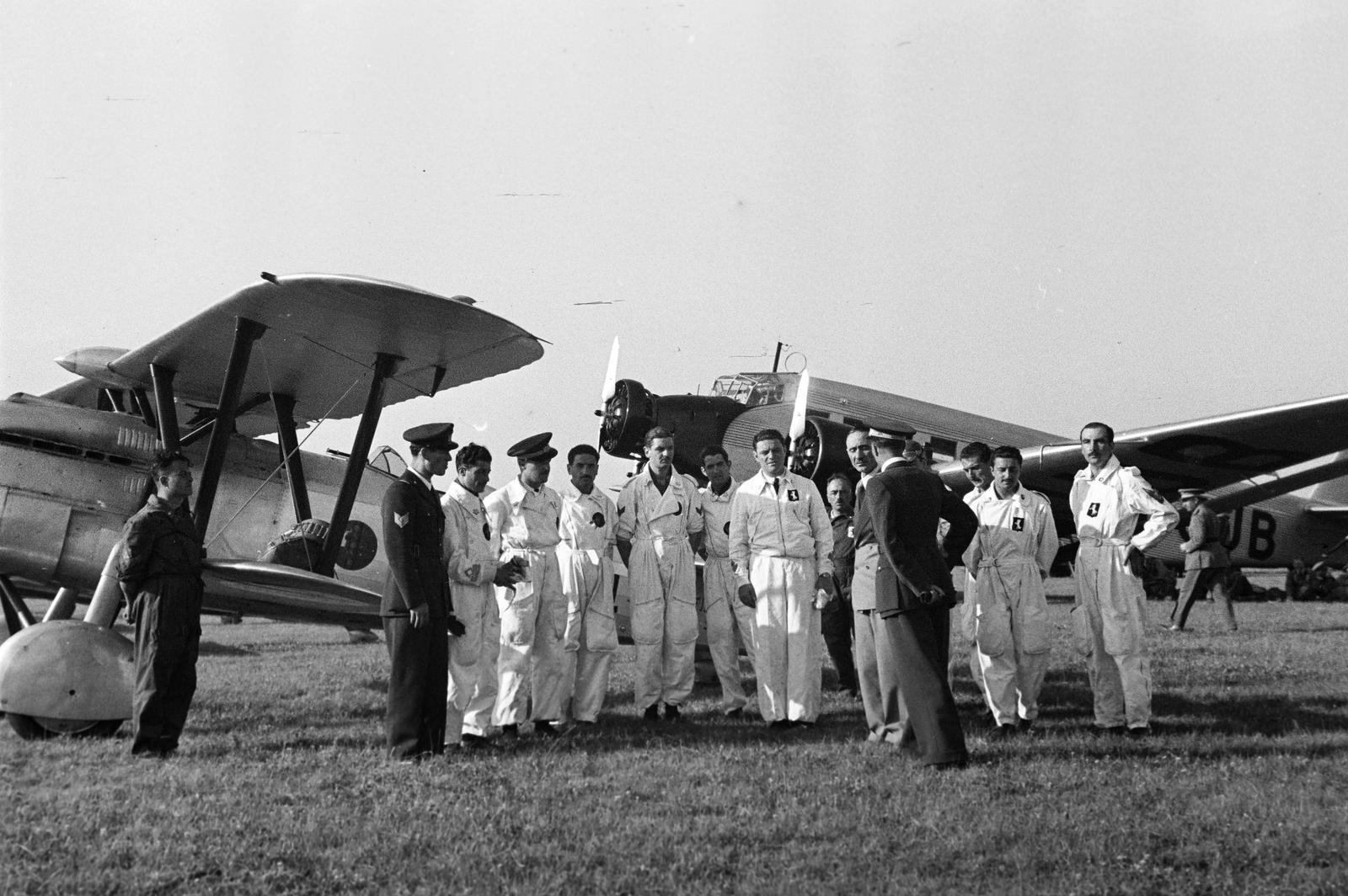 Hungary, Budaörs Airport, Budapest XI., a felvétel a repülőtér ünnepélyes átadása napján, 1937. június 20-án készült. Olasz Fiat CR.32 típusú repülőgép előtt az olasz vadászrepülő század pilótái, jobbra a háttérben egy Junkers Ju-52 típusú repülőgép., 1937, Inkey Tibor, Fiat-brand, pilot, Budapest, Fortepan #306077