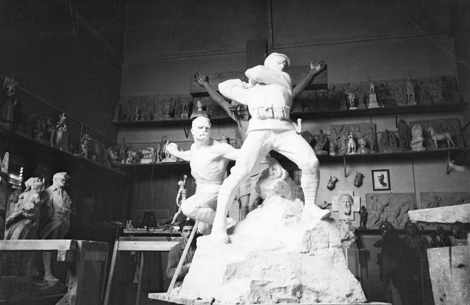 Magyarország, Budapest V., az 1. honvéd és népfölkelő gyalogezred emlékművének gipszmintája Siklódy Lőrinc műtermében. A háttérben jobbra a tihanyi IV. Károly király emlékére emelt kálvária Krisztus-alakjának részlete., 1938, Inkey Tibor, műterem, szobor, Budapest, Fortepan #306222