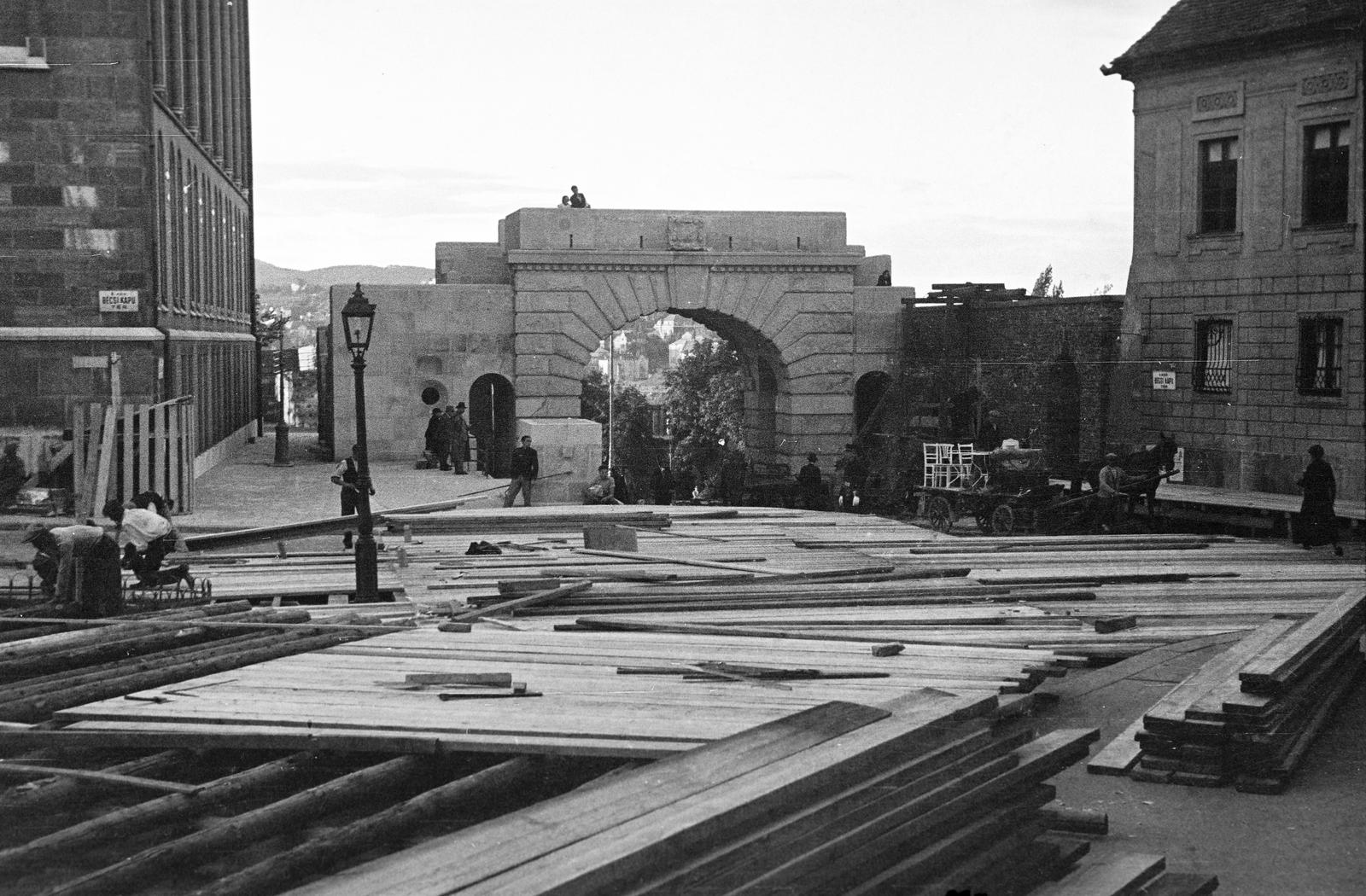 Magyarország, budai Vár, Budapest I., Bécsi kapu tér a Budavári Evangélikus templom előtt. A főemelvény ácsolása, Ohmann Béla alkotásának, a Budavár visszavételének emlékműve avatási ünnepségére. A talapzat mögött a Bécsi kapu látható, balra a Magyar Országos Levéltár épülete., 1936, Inkey Tibor, deszkarakás, építkezés, Budapest, Fortepan #306274