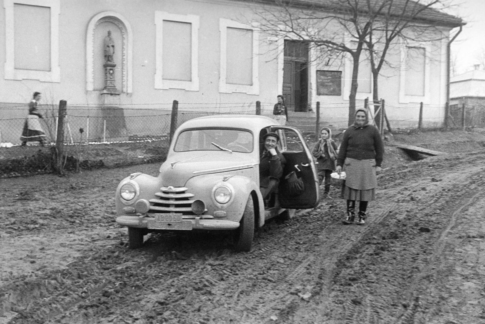 Magyarország, Csitár, Petőfi út, a 88. számú ház oldalhomlokzatán Keresztelő Szent János szobra., 1958, Gazda Anikó, Best of, szoborfülke, mosoly, földút, középület, rendszám, automobil, sár, Skoda 1101/1102 Tudor, Fortepan #307071