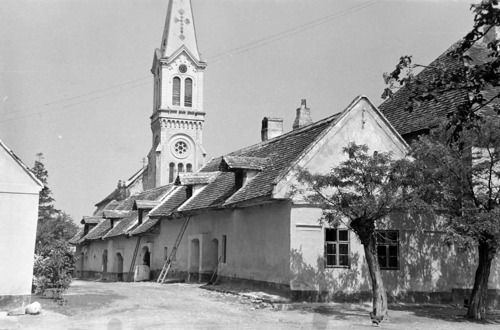 Magyarország, Harka, (Magyarfalva) Nyéki utca az Árpád-kori templom mellett, a háztető felett az evangélikus templom látható., 1963, Gazda Anikó, Fortepan #307469