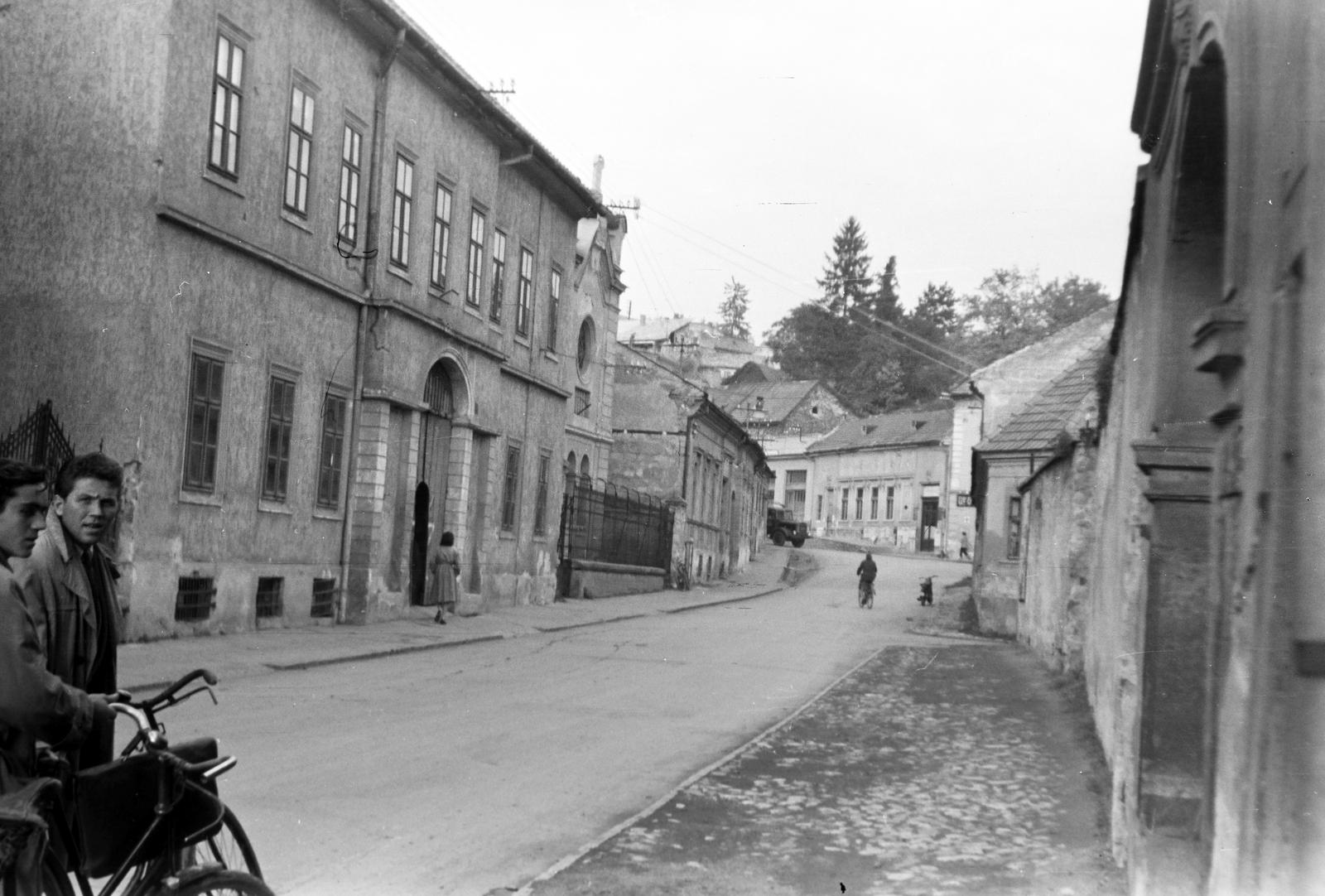 Magyarország, Eger, Kossuth Lajos utca, szemben a kerítés mögött az egykori Ortodox zsinagóga, később Zsinagóga Galéria, majd Ziffer Sándor Galéria. A teherautó mögött a Tinódi Sebestyén (Dózsa György) térnél álló épületek láthatók., 1960, Gazda Anikó, Fortepan #308211