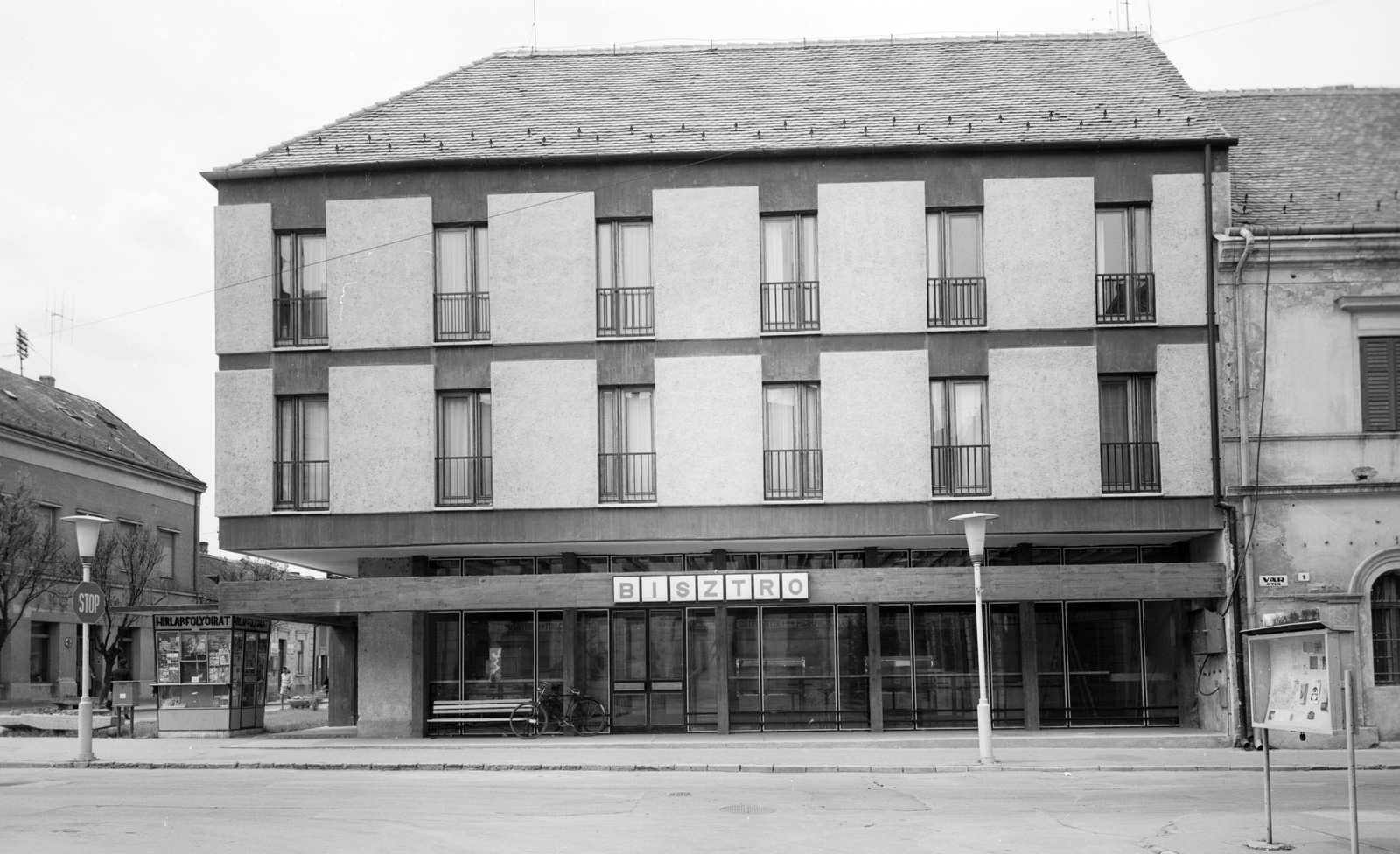 Magyarország, Szigetvár, Zrinyi tér, Oroszlán Szálló a Széchenyi utca torkolatánál, jobbra a Vár utca., 1973, Építésügyi Dokumentációs és Információs Központ, VÁTI, vendéglátás, utcakép, hirdető tábla, lámpaoszlop, postaláda, újságárus, pavilon, utcanévtábla, bisztró, Fortepan #31026