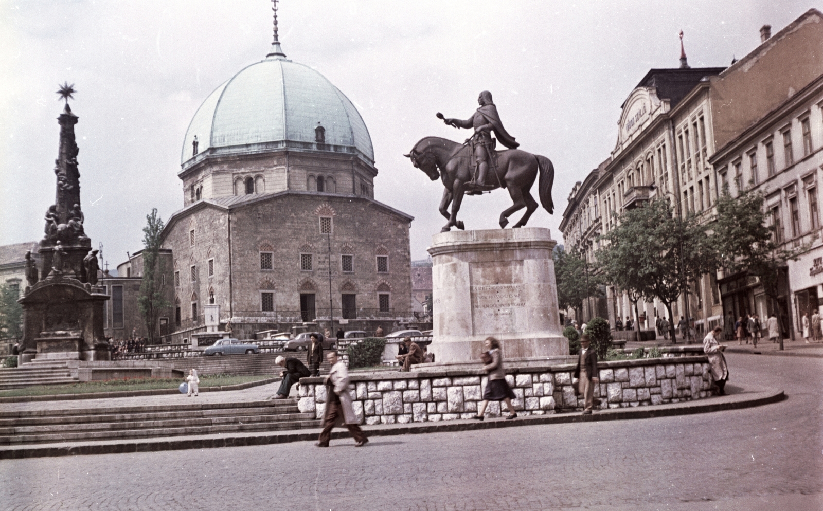 Magyarország, Pécs, Széchenyi tér, a Dzsámi előtt a Szentháromság-szobor és Hunyadi János szobra., 1958, Építésügyi Dokumentációs és Információs Központ, VÁTI, templom, színes, szobor, emlékmű, járókelő, utcakép, életkép, lovas szobor, Hunyadi János-ábrázolás, Fortepan #31209