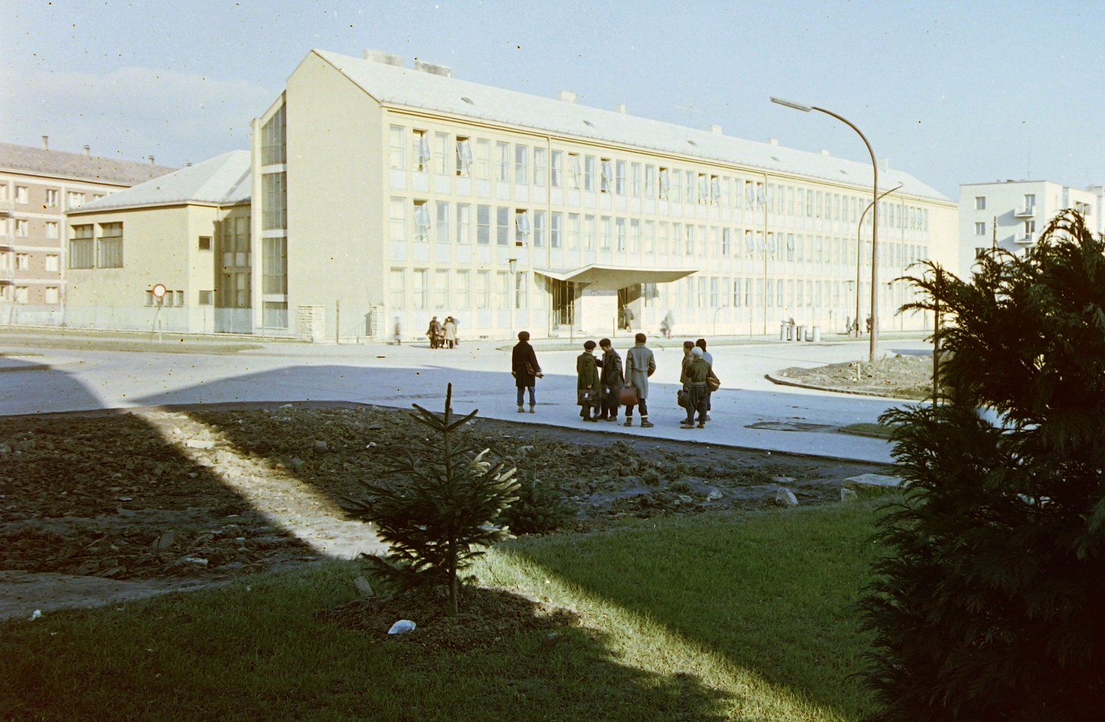 Hungary, Uránváros, Pécs, Esztergár Lajos utca (39-es dandár út) - Bánki Donát utca sarka, a Randóti Miklós Gazdasági Szakközépiskola épületével., 1959, Építésügyi Dokumentációs és Információs Központ, VÁTI, colorful, blocks, street view, genre painting, kids, lamp post, beret, briefcase, Fortepan #31288