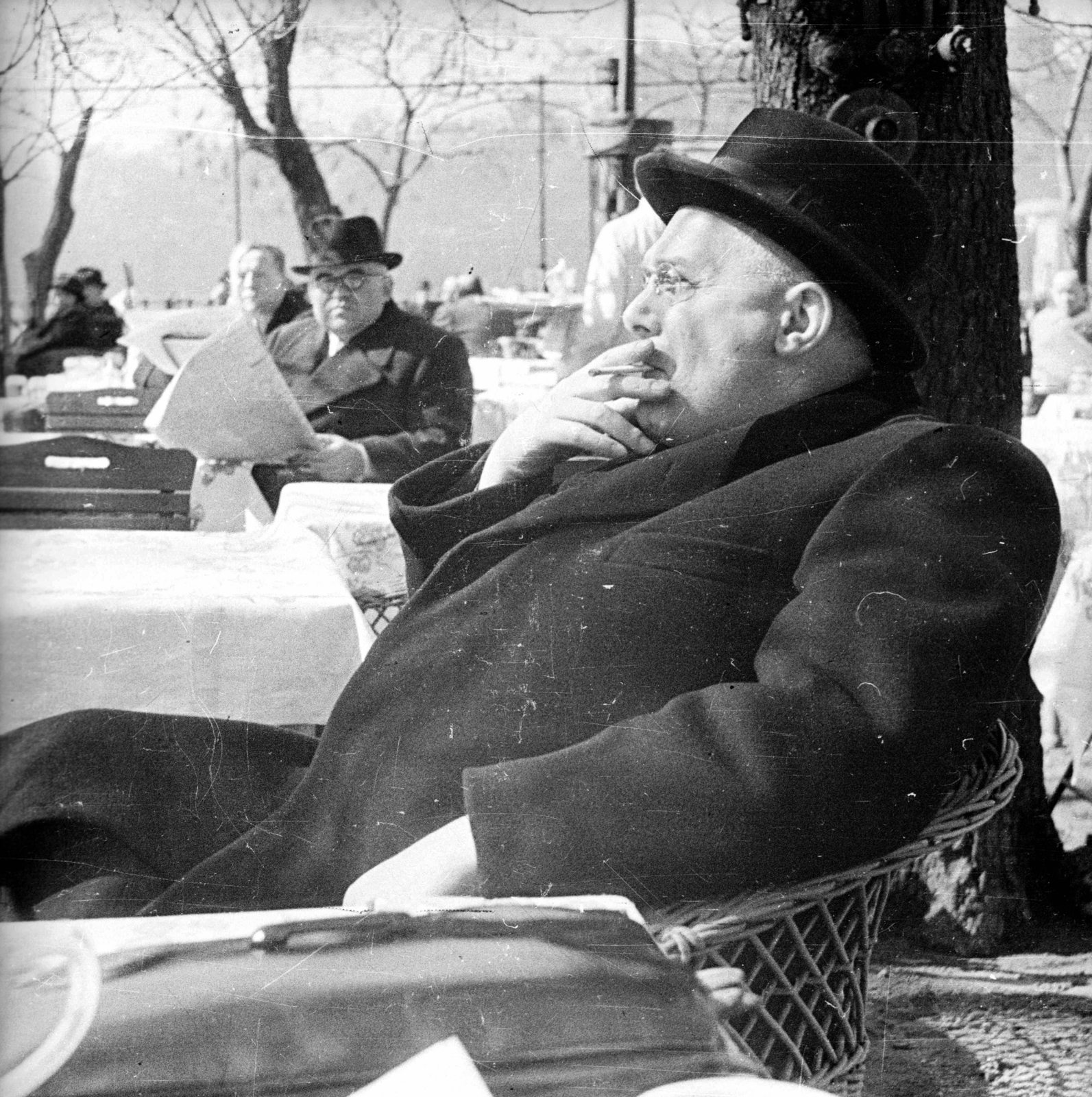 Hungary, Budapest V., Vigadó tér, a Hangli kávéház terasza., 1941, Ludovika, portrait, hat, cigarette, smoking, wicker chair, newspaper, garden furniture, Budapest, Fortepan #3203