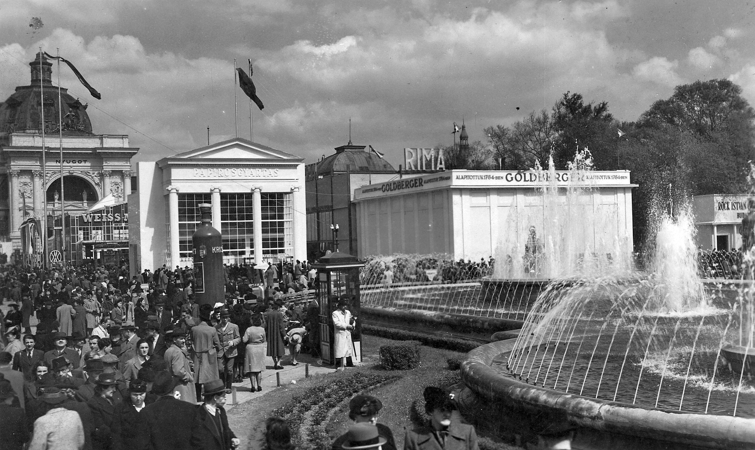 Magyarország, Városliget,Budapesti Nemzetközi Vásár, Budapest XIV., háttérben az Iparcsarnok., 1941, Pesti Brúnó, szökőkút, zászló, cégtábla, tömeg, nemzetközi vásár, telefonfülke, címer, vásár, pavilon, Goldberger Sámuel és Fiai Rt, Budapest, Christian Ulrich-terv, Rimamurány-Salgótarjáni Vasmű Rt, Weiss Manfréd-márka, Fortepan #32602