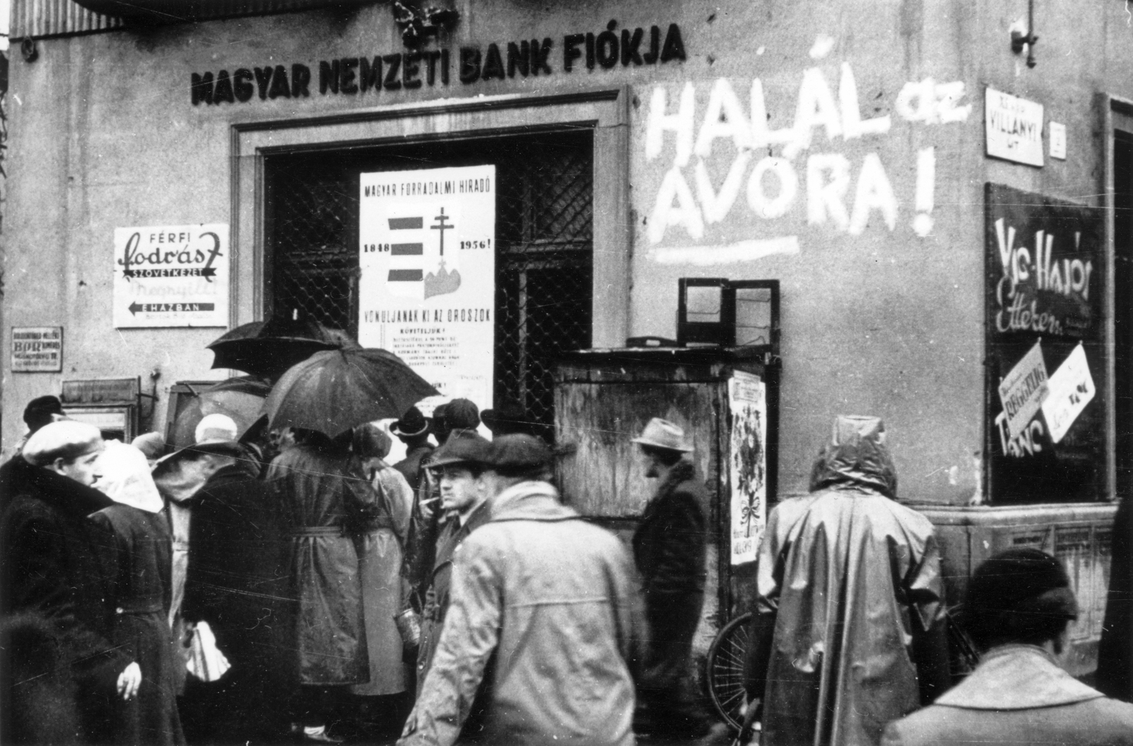 Magyarország, Budapest XI., Móricz Zsigmond körtér - Villányi út sarok., 1956, Pesti Srác2, reklám, kalap, plakát, cégtábla, felirat, forradalom, életkép, esernyő, svájcisapka, esőkabát, címer, bank, Kossuth címer, Budapest, Fortepan #32776