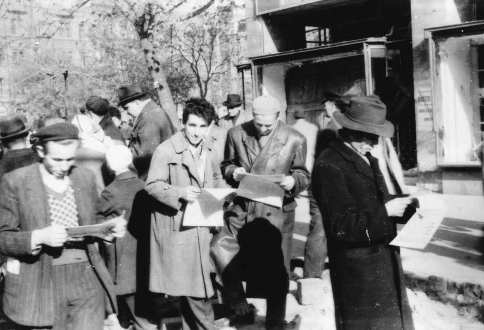 Magyarország, Budapest VIII., Rákóczi tér - József körút sarok., 1956, Pesti Srác2, kalap, forradalom, utcakép, újság, svájcisapka, bőrkabát, csoportosulás, Budapest, Fortepan #32784