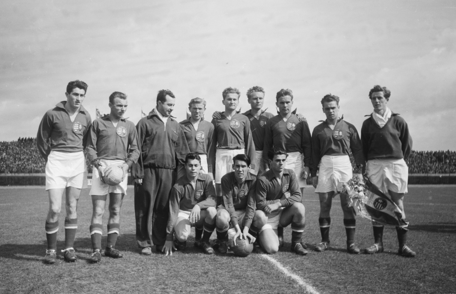 Czech Republik, Prague, Strahov stadion, Csehszlovákia - Magyarország (3:1) ifjúsági válogatott labdarúgó-mérkőzés. Balról jobbra: Fábián, Tóth II., Mandik Béla edző, Sólyom (Schuman), Szigeti (Schmidt), Mednyánszky, Guba, Anda csapatkapitány, Domonkos kapus, guggolnak: Sárosi, Palotás, Csáki., 1949, Kovács Márton Ernő, Czechoslovakia, football, soccer team, stadium, squatting, arms around shoulders, Fortepan #32815