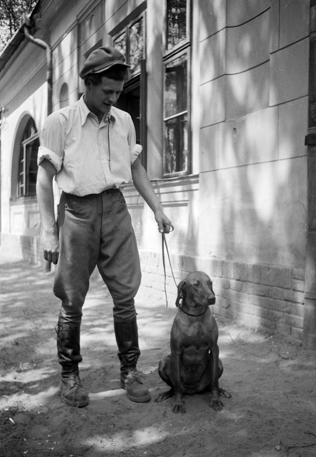 Hungary, Gödöllő, a MÁLLERD (Magyar Állami Erdőgazdasági Üzemek) kutyatelepe, ifj. Jilly Bertalan telepvezető magyar vizsla idomítására indul., 1949, Kovács Márton Ernő, dog, Bilgerie boots, leash, Fortepan #32939