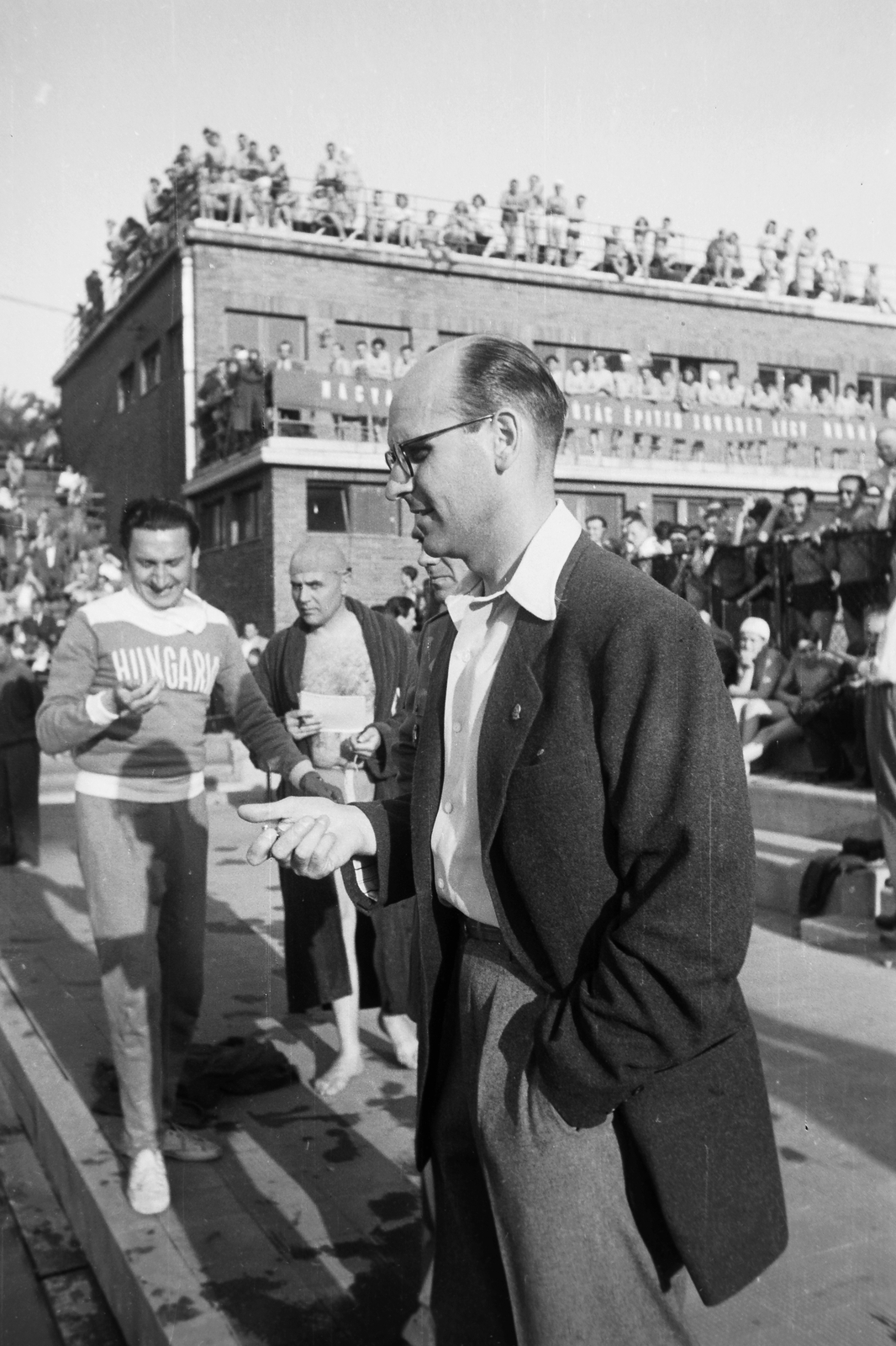Hungary, Margit Islands, Budapest, Hajós Alfréd Nemzeti Sportuszoda. Edzők, kezükben stopperrel figyelik versenyzőiket. Előtérben Rajki Béla, tőle hátrébb melegítőben Hunyadfy István., 1949, Kovács Márton Ernő, swimming championship, Alfréd Hajós-design, hands in pockets, Fortepan #32945