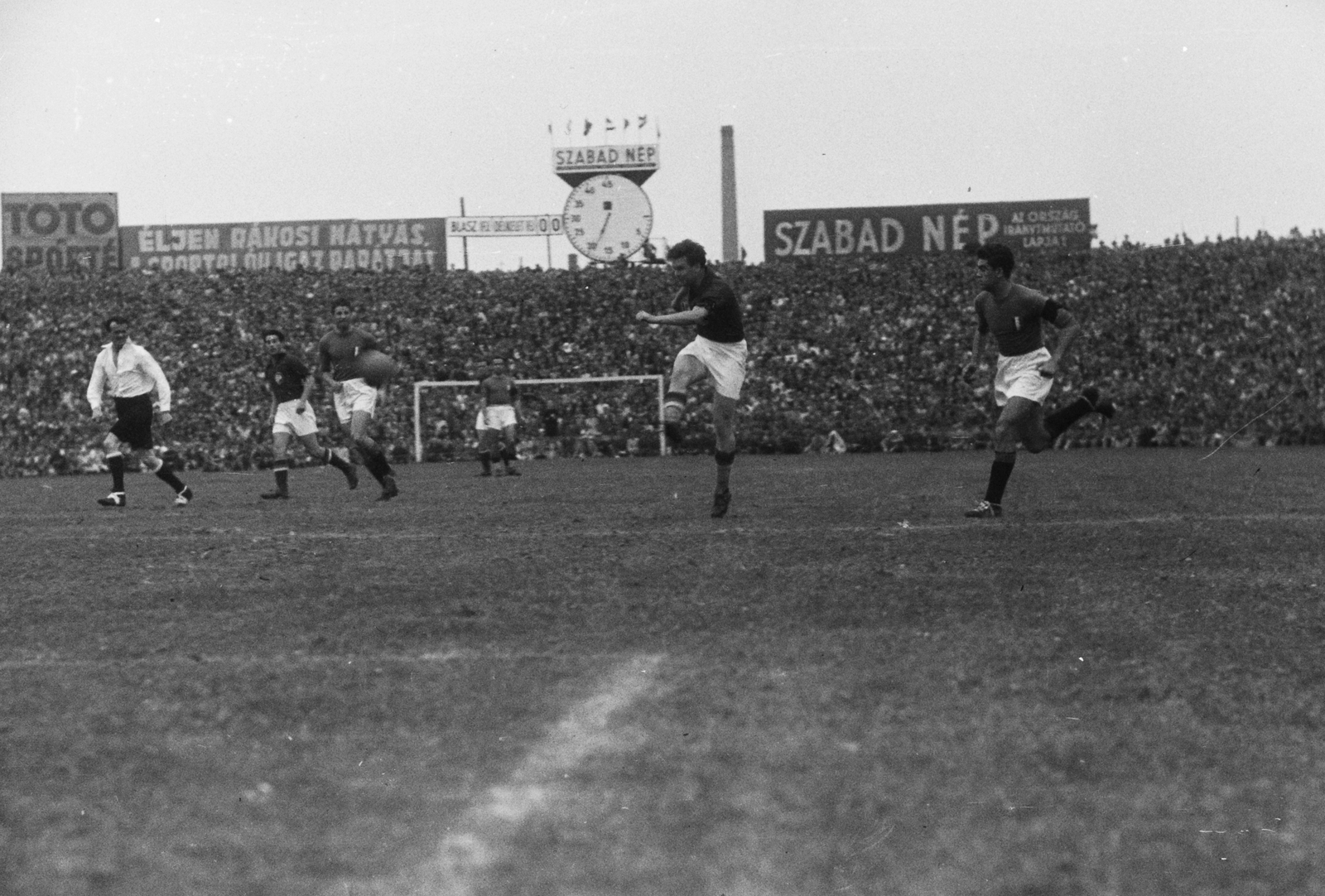 Magyarország, Budapest IV., Újpest, Megyeri út, UTE pálya, Magyarország - Olaszország (1:1) válogatott labdarúgó-mérkőzés. Szusza kapura lő., 1949, Kovács Márton Ernő, Budapest, köztéri óra, reklám, labdarúgás, Fortepan #33173