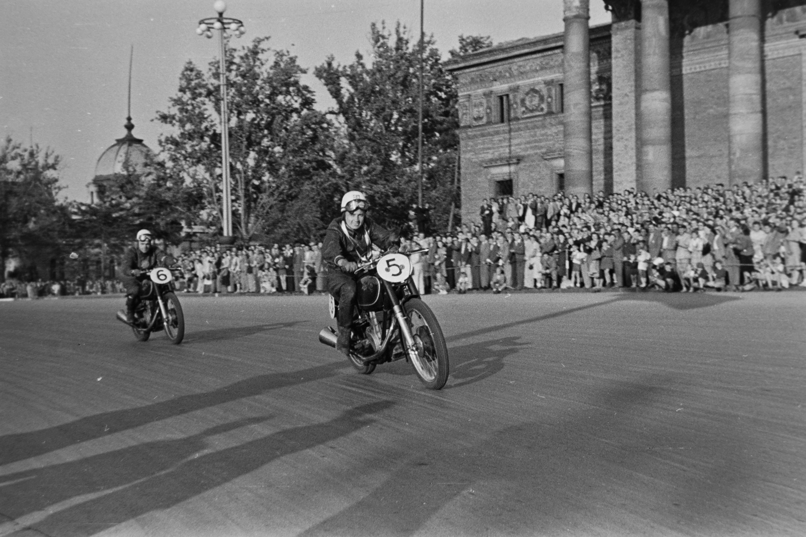 Hungary, Budapest XIV., Hősök tere, háttérben a Műcsarnok. A Motorsportszövetség és a Mogürt nemzetközi motorversenye. 5-ös rajtszámmal a győztes Szabó I László (Kuksi), mögötte 6-ossal Lukavecz Ferenc., 1949, Kovács Márton Ernő, motorcycle, museum, crash helmet, motorcycle race, Budapest, Albert Schickedanz-design, Neoclassical architecture, audience, Fortepan #33261